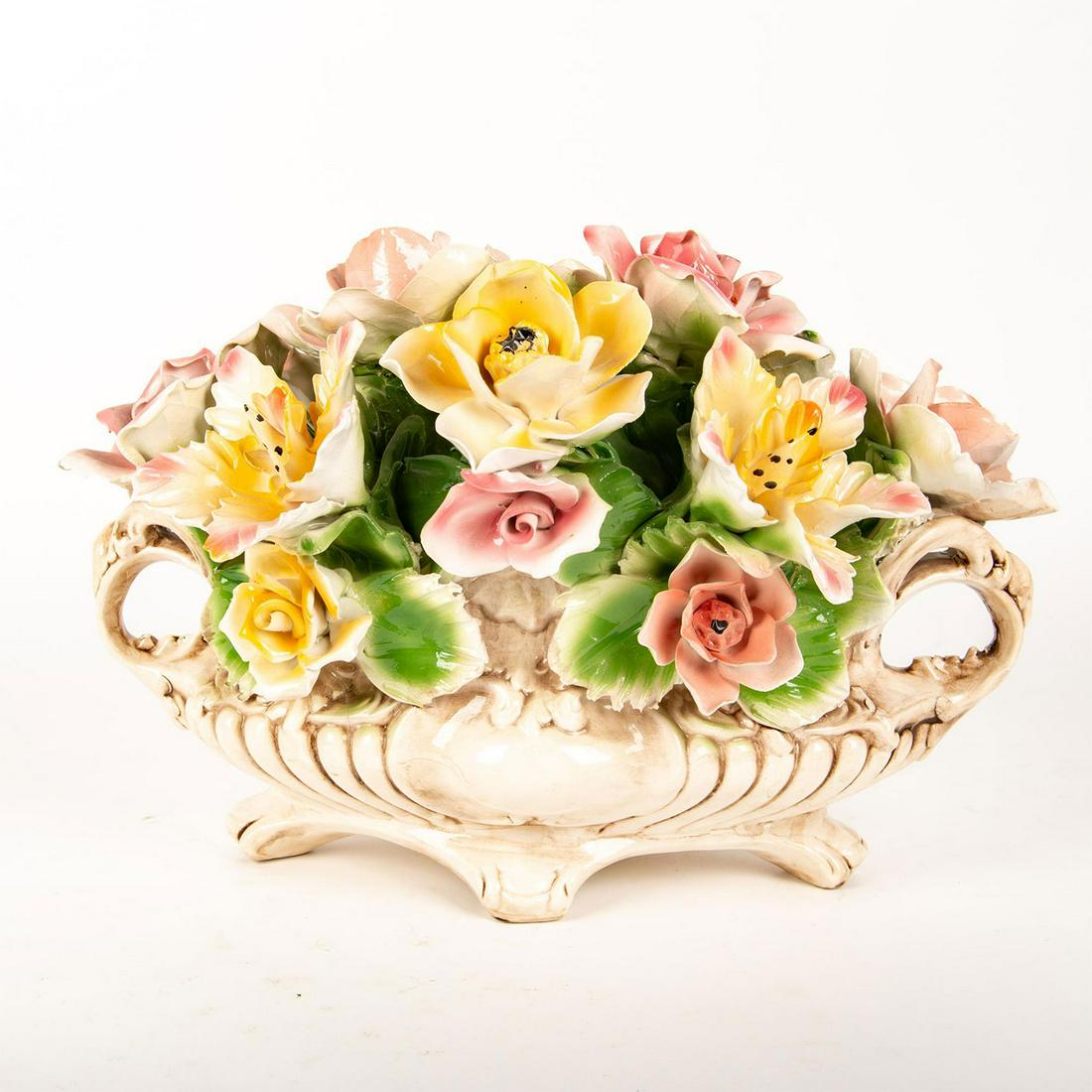 Capodimonte Porcelain Large Floral Footed Centerpiece: Hand painted and decorated in high-relief with large pastel colored flowers. Scrolled designed in high-relief with elaborate double handles. Capodimonte mark and Made In Italy. Small chips to tips of