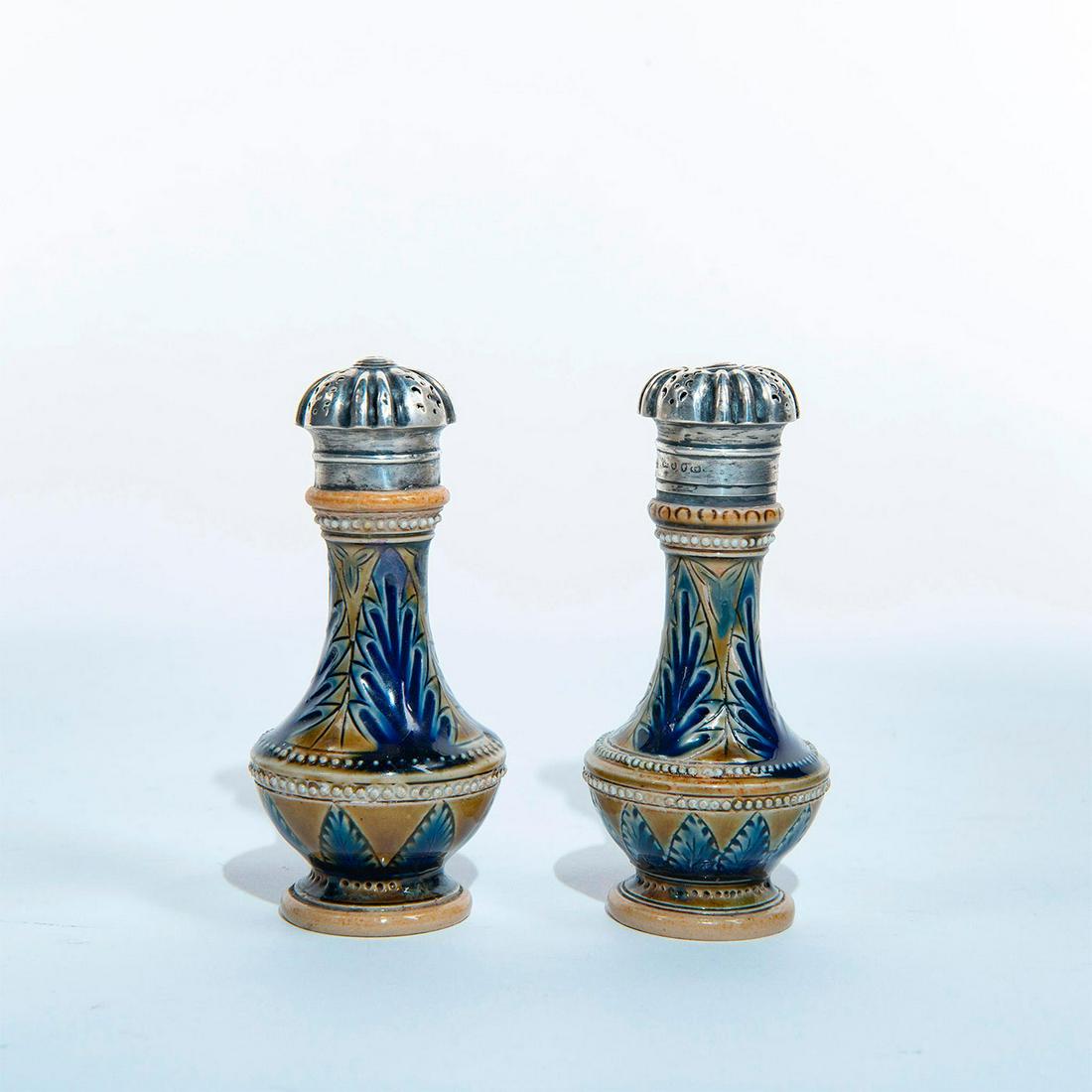 Pair of Doulton Lambeth Stoneware Shakers: Incised cobalt blue floral designs with applied beaded decor. Hallmarked silver tops. Impressed Doulton Lambeth mark and artist initials EES to bottom base. Artist: Emily Stormer Issued: 1875 Dimensio
