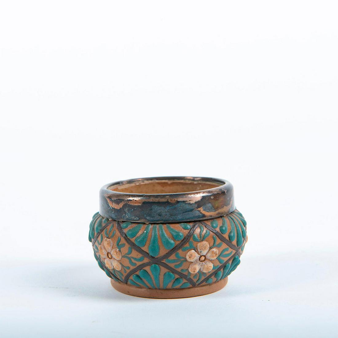 Doulton Lambeth Silicon Ware Open Salt Cellar: Brown tone, decorated with applied and hand painted decorations. Mounted, hallmarked silver rim. Doulton Lambeth Silicon Ware mark. Silver with signs of tarnish. Issued: Late 19th c. to early 20th c. 