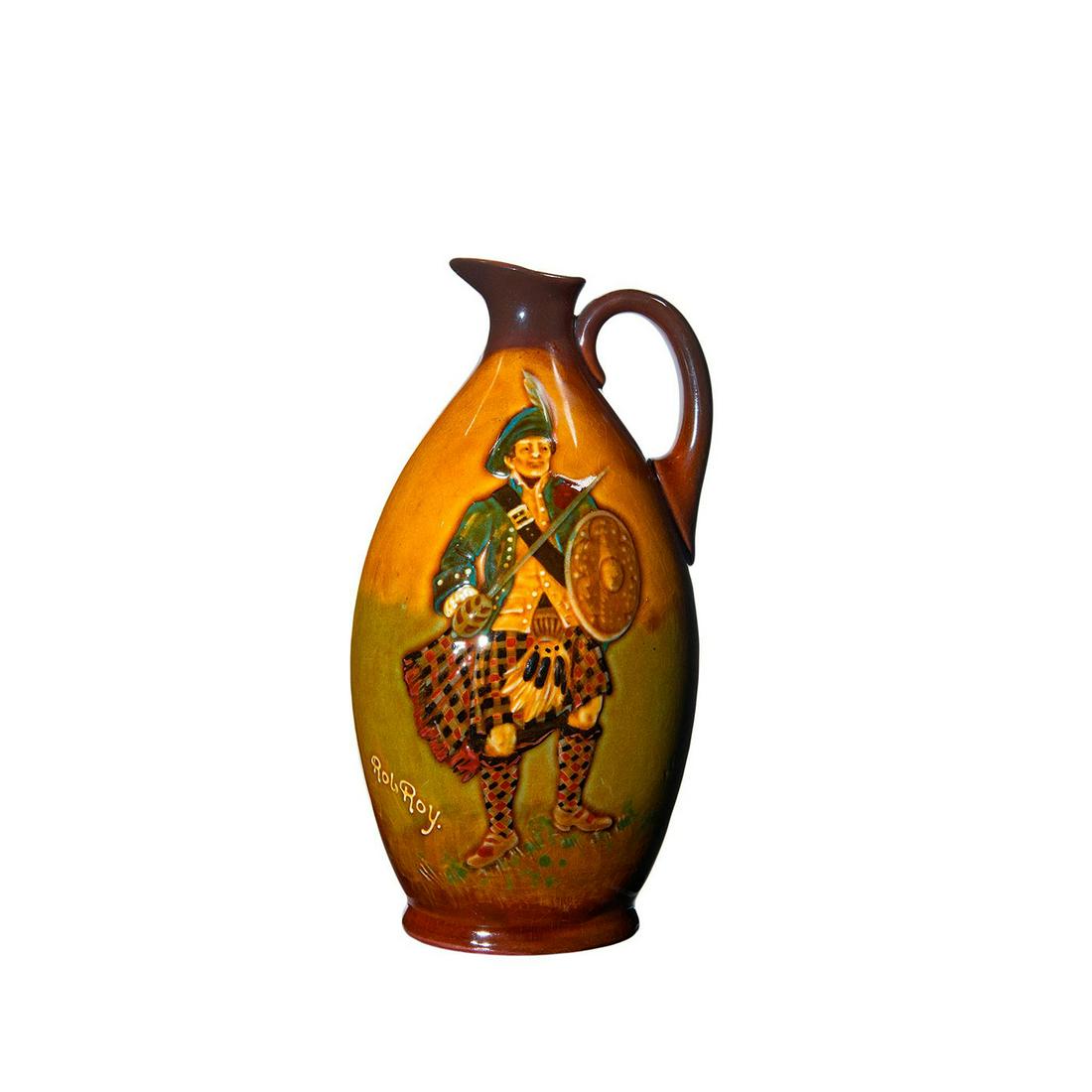 Royal Doulton Kingsware Whisky Jug, Rob Roy: Greenlees Brothers Claymore Scotch Whisky Distillers. Brown glaze; features Rob Roy. Signed Noke. Doulton backstamp. Crazing to body. Artist: C. Noke Issued: c. 1912 Dimensions: 9"H Manufacturer: Roya