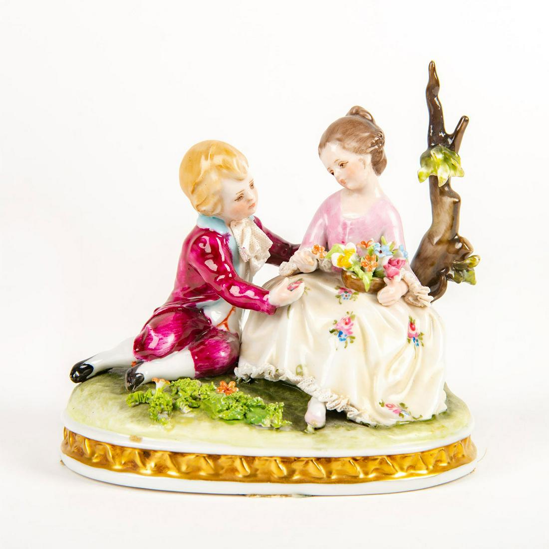 Capodimonte Style Figural Group, Boy And Girl With: Hand painted porcelain; lace detail; gilt highlights. Young boy and girl seated by tree. Crowned N mark on the underside. Marked MADE - ITALY on base. Issued: 20th c. Dimensions: 5.25"H Country of Ori