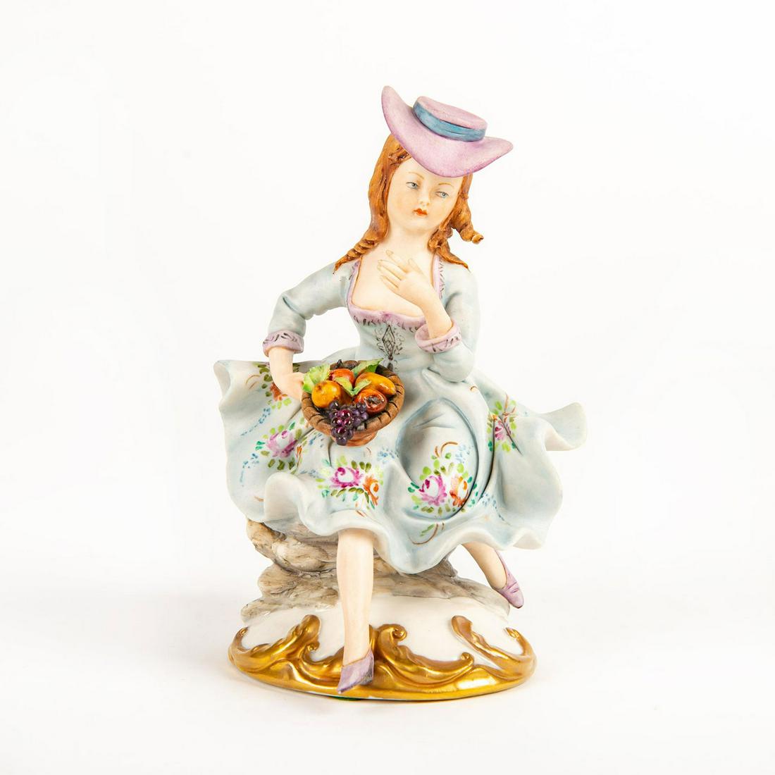 Capodimonte Volta Bisque Porcelain Figurine, Fruit: Hand painted on rococo style base depicting a woman with a fruit basket. Artist signed. Capodimonte blue stamp. Issued: 20th c. Dimensions: 6"H Manufacturer: Capodimonte Country of Origin: Italy