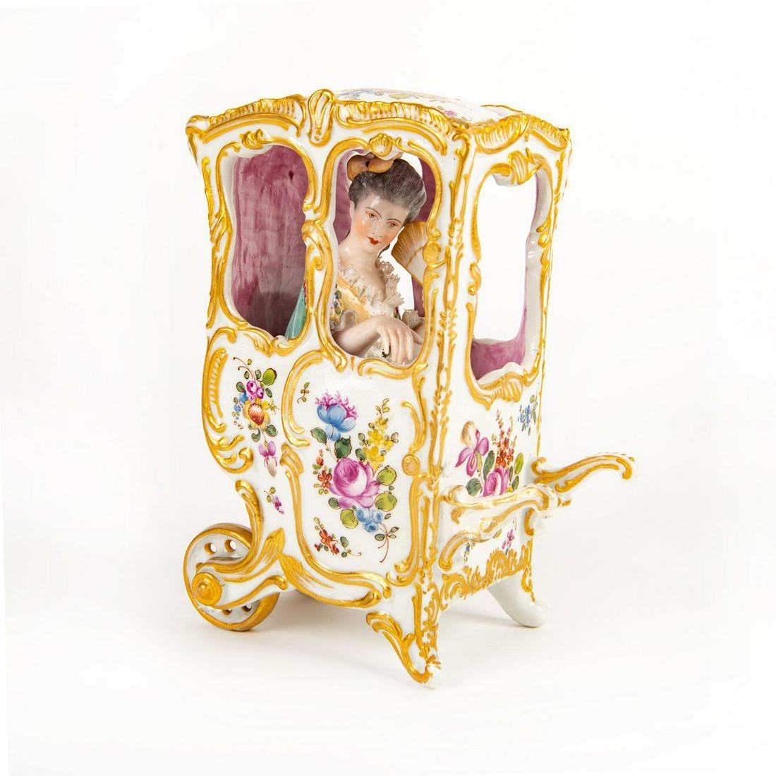 Porcelain Lace Figural Group, My Lady In A Carriage: Hand painted, depicting a lady seated in heavily decorated floral, gilded carriage holding a hand fan. Lace trimming to dress. Missing finials, restored shaft tip. Blue crossed sword mark with letters