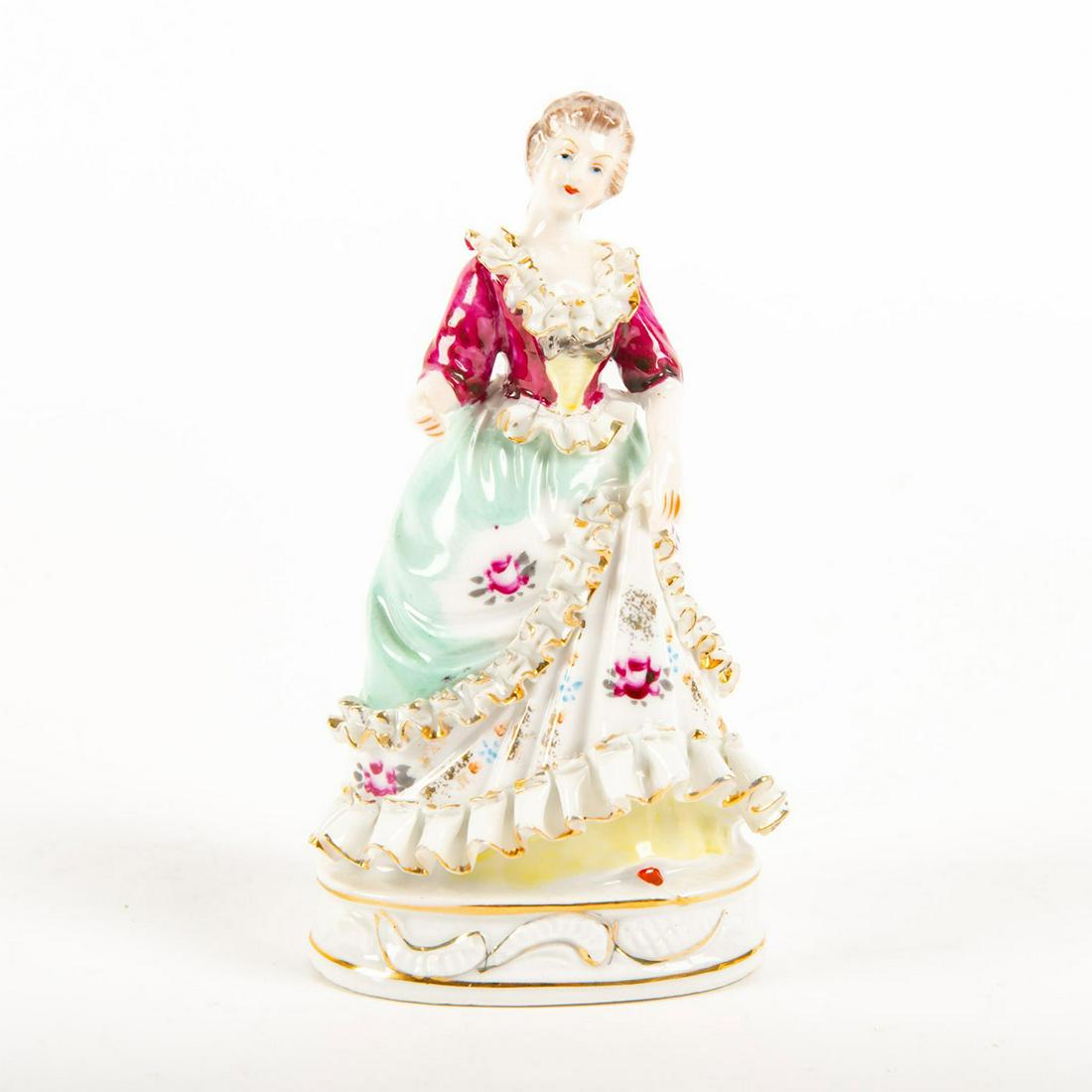 Porcelain Miniature Figurine, Lady In Floral Dress: Hand painted, pink and turqoise colorway dress with pink roses, trimmed in gilded lace. Oval gilded base with high-relief scroll designs. Embossed double crossed sword mark to bottom base.Damage to la