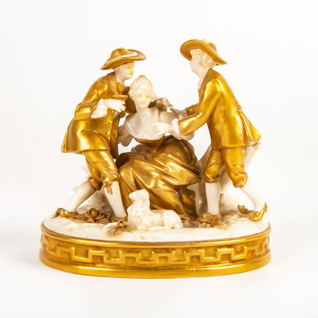 Small Gilded Porcelain Figural Group: Hand painted in gold gilt; depicting two lads and a lady with a lamb by her side. Applied floral gold metals to base. Damaged feather from hat. Broken pinky finger from ladies right hand. Blue crown m