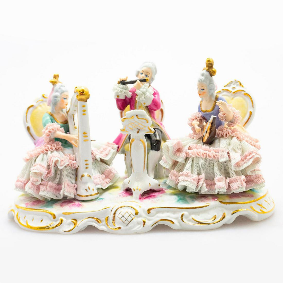 Wilhelm Rittirsch Dresden Art Figure Group, Musical: Lace porcelain; hand painted. Includes woman playing the mandolin, flutist and harpist. Rests on oval base; gilt highlights. WR Dresden Art backstamp. Chips to lace; broken mandolin and harp strings. 