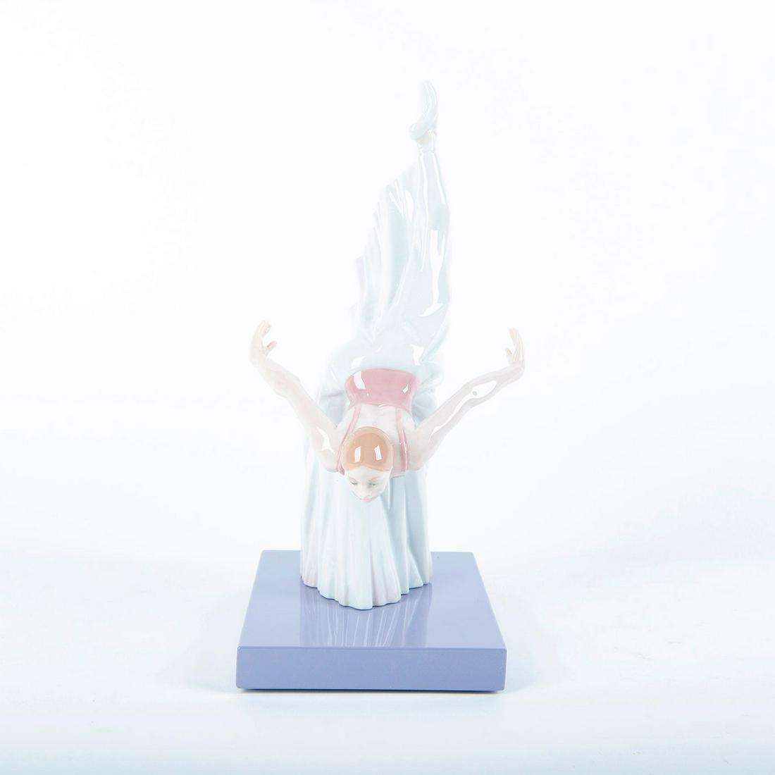 Lladro Porcelain Figurine, Giselle Reverence 01008474: Baller dancer in a long pleated skirt practicing an elegant pose; mounted on base. Includes original box. Pink and white colorway; glossy porcelain. Lladro backstamp. Artist: Javier Molina Issued: 200