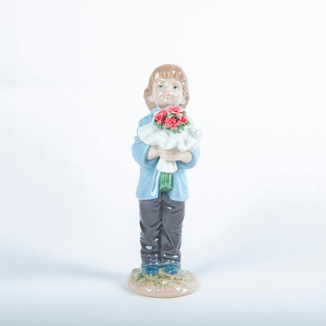 Lladro Porcelain Figurine, You Deserve The Best: Glossy porcelain figurine of a child with a huge bouquet of red carnations. Lladro backstamp. Includes original box. Artist: Jose Santaeulalia Issued: 2010 Dimensions: 7"H Country of Origin: Spain Man