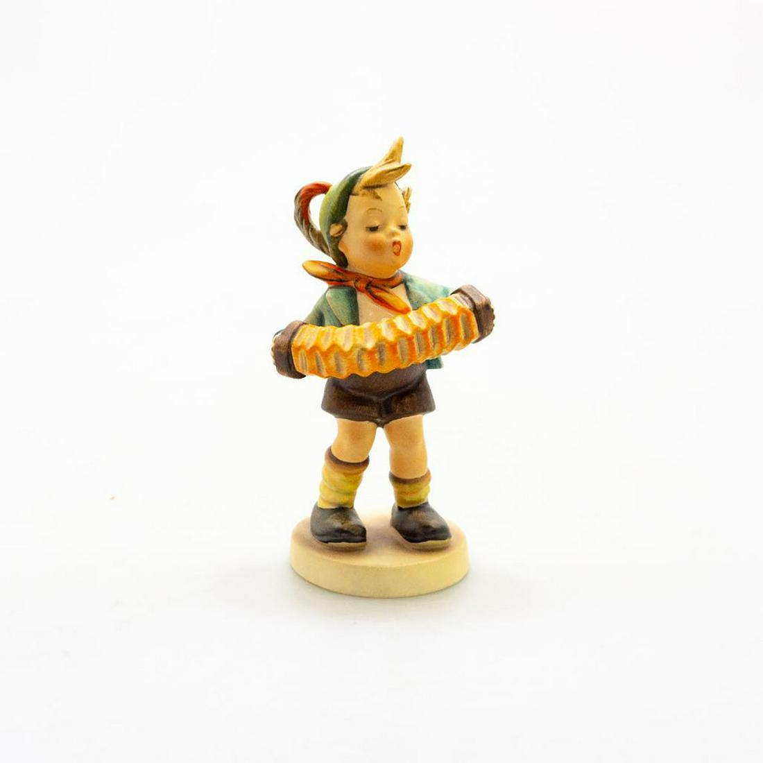 GOEBEL HUMMEL FIGURINE, ACCORDION BOY #185: A boy stands singing and playing his accordion. Dimensions: 5.5"H Manufacturer: Goebel Country of Origin: Germany