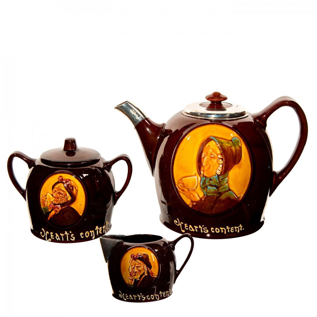 3pc Royal Doulton Kingsware A Cup That Cheers Tea Set: Gorgeous Kingsware Teapot in lusiocious brown glaze, designed in high relief. There is an older lady sitting tea in the front of the pot, creamer and on the sugar bowl. Embossed reads: Heart's Content