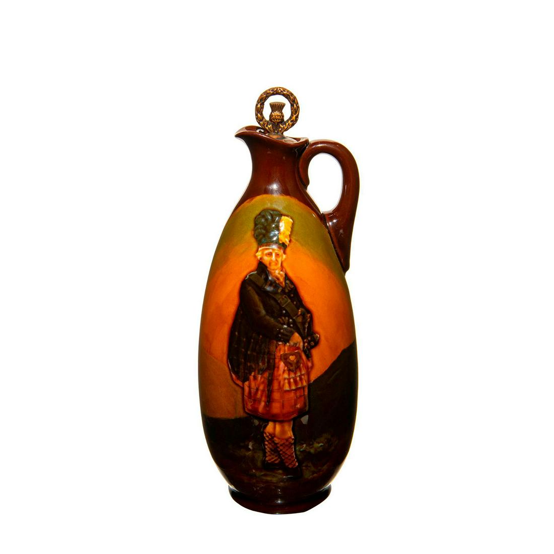 Royal Doulton Kingsware Whiskey Bottle of The Macnab: Doulton whisky bottle in dark brown, light brown and gold. One side has Macnab and the other says Dewar's Whisky. Gold cork top. Royal Doulton backstamp. The Macnab subject was taken from a portrait o