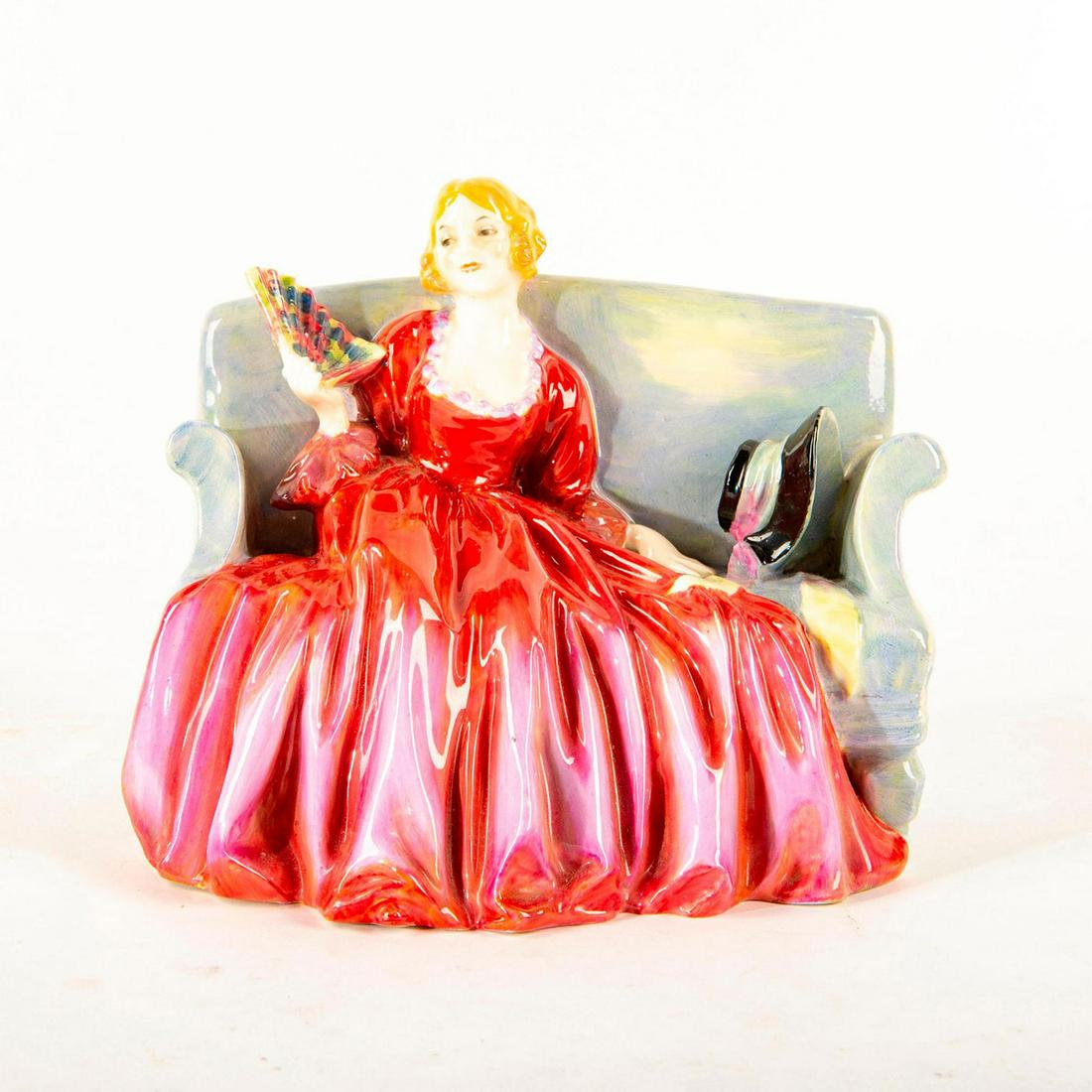 Sweet And Twenty HN1298 - Royal Doulton Figurine: Harradine Classics. Woman seated in couch holding a fan. Titled on base. Marked, Potted By Doulton And Co. Doulton backstamp. Artist: Leslie Harradine Issued: 1928-1969 Dimensions: 5.75"H Manufacturer
