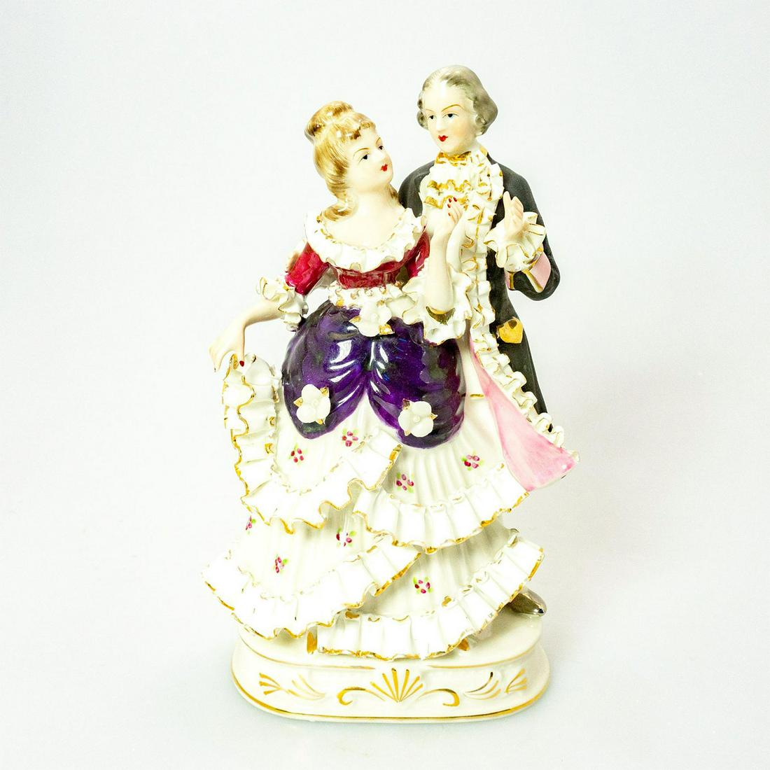 Vintage Bone China Figural Group, Couple Dancing: Black, pink, purple and white coloration; gilt highlights. Ruffled lace accents. Green crossed swords backstamp. Marked on base. Issued: 20th c. Dimensions: 8.5"H