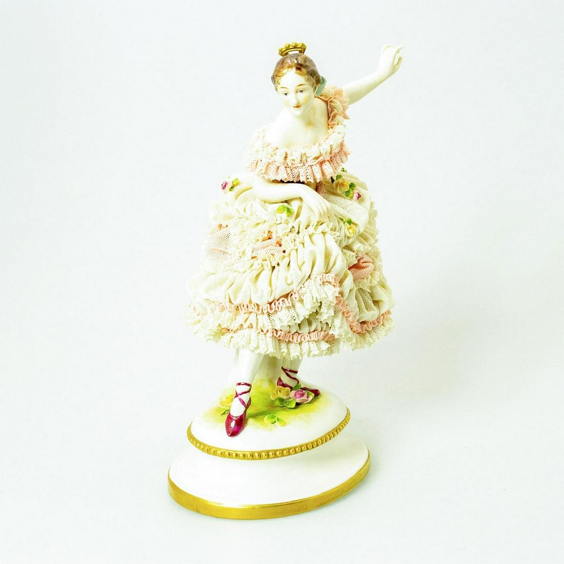 Vintage German-style Porcelain Lace Figurine, Ballerina: A ballerina in a layered dress stands in a pose with leg extended. Delicate flowers decorate her dress. Her hair comb is gilt painted. Unmarked on the underside. Issued: 20th c. Dimensions: 9.75"H