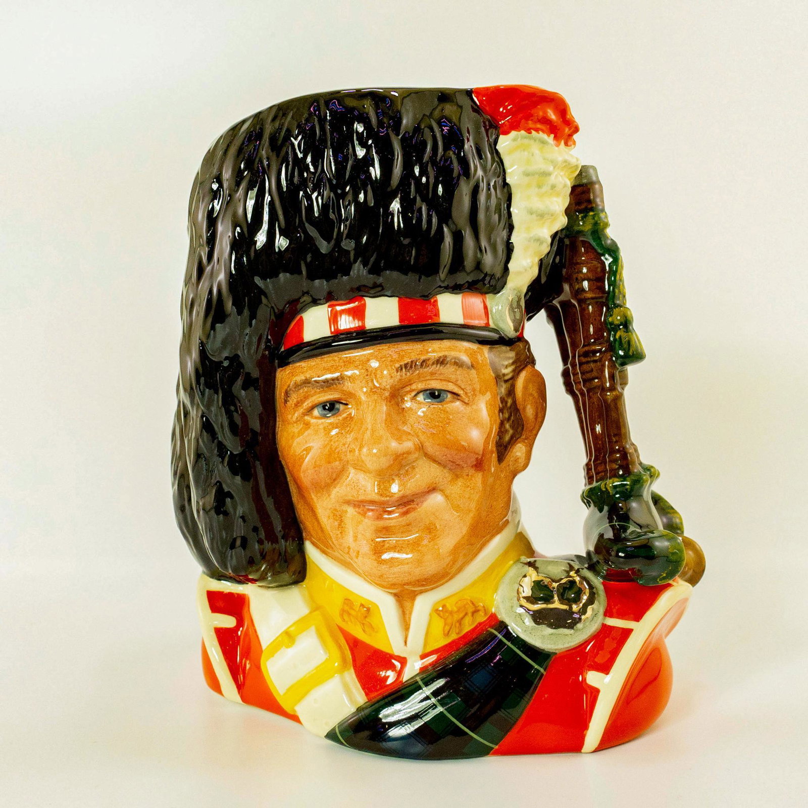 The Piper D6918 - Large - Royal Doulton Character Jug: Royal Doulton Character Jug, Piper D6918 (black, red, white and yellow coloration). The Piper jug was issued in a limited edition of 2,500 pieces. Artist: Stanley J. Taylor Dimensions: 8.25"H Country 