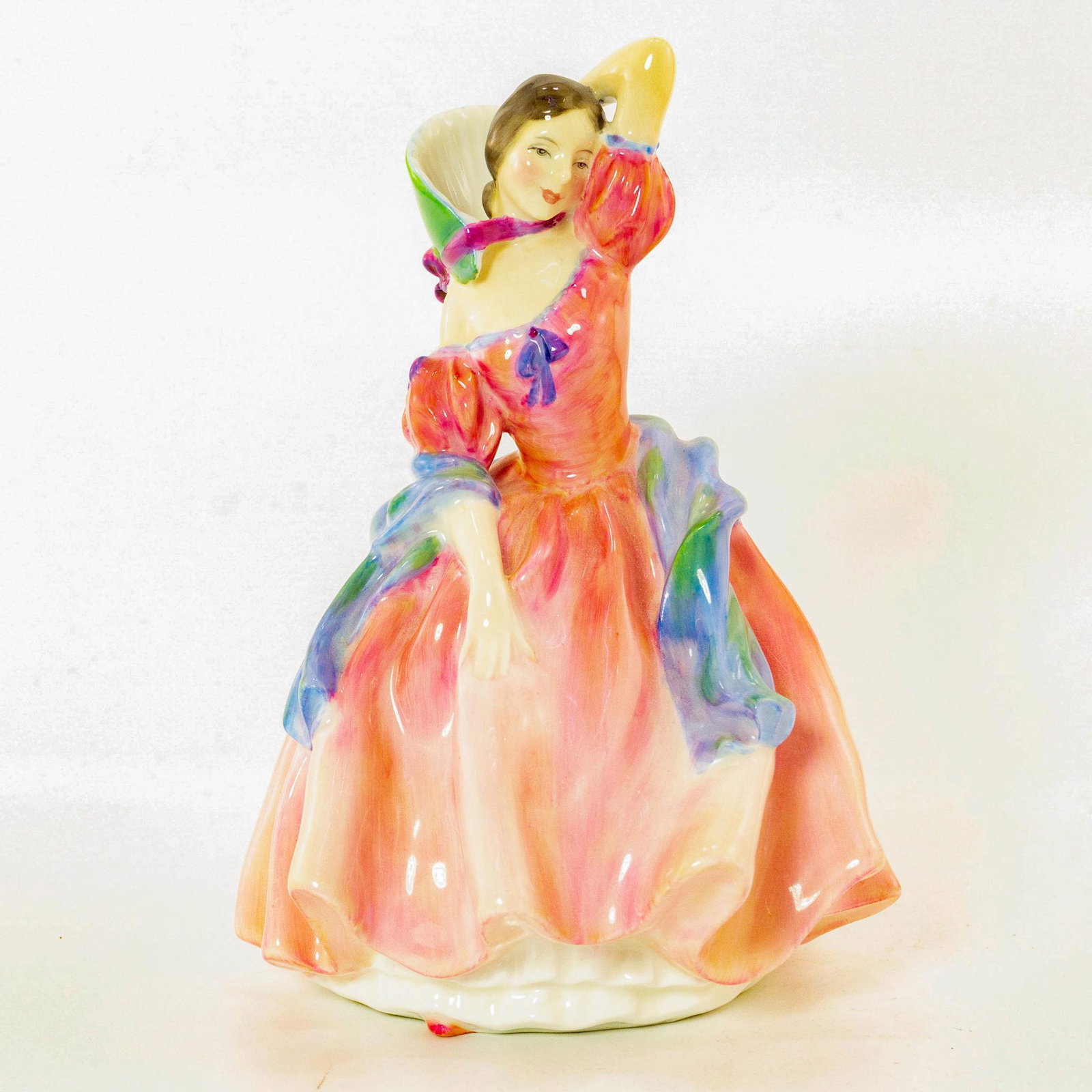 Maytime HN2113 - Royal Doulton Figurine: Harradine Classics. Pink dress with blue scarf. Porcelain; glazed. Doulton backstamp. Artist: Leslie Harradine Issued: 1953-1967 Dimensions: 7.25"H Manufacturer: Royal Doulton Country of Origin: Engla