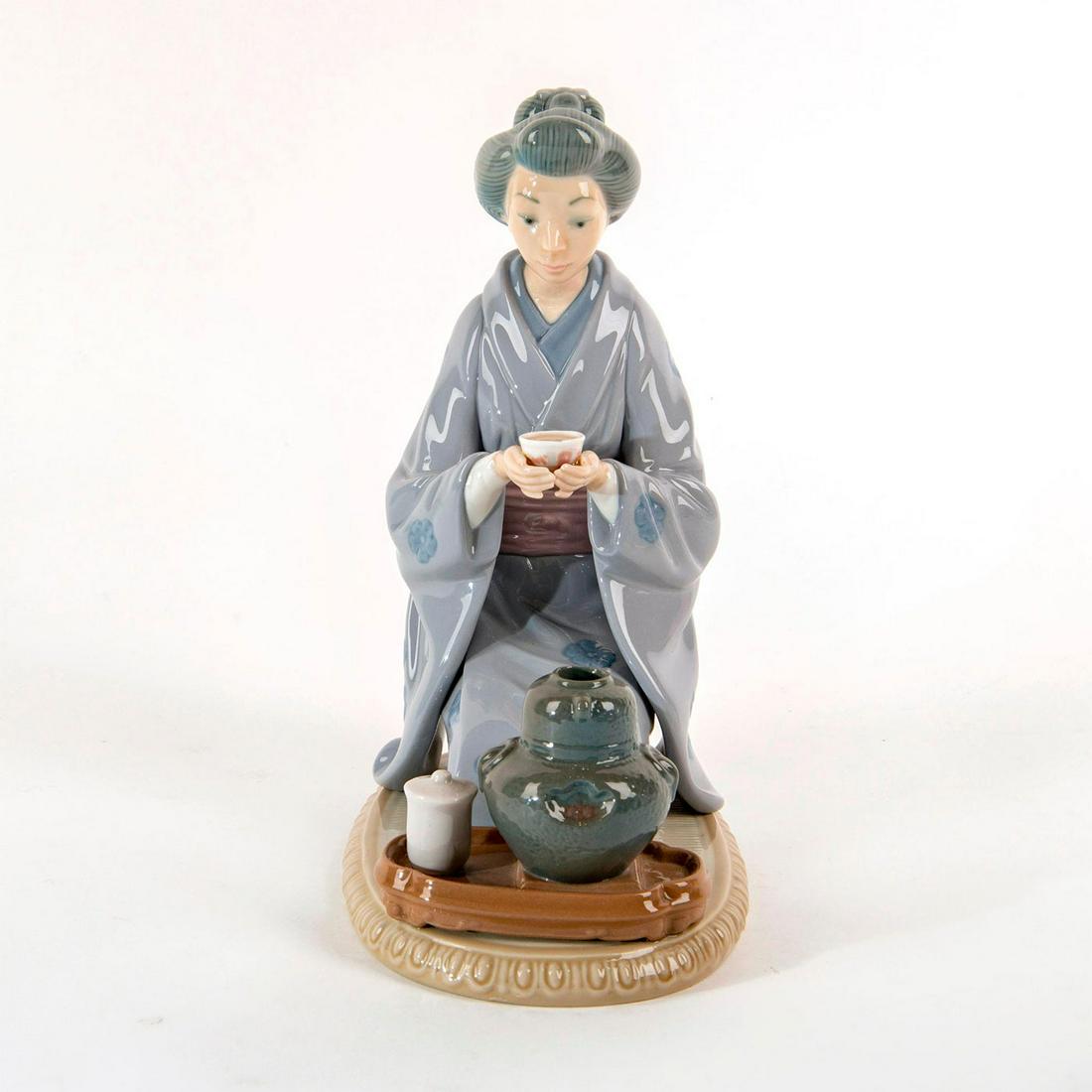 August Moon 1982/1993 1005122 - Lladro Porcelain Figure: Glazed figure, oriental woman holding cup; Tea vessel is on table below her. No box. Dimensions: 8.75"H