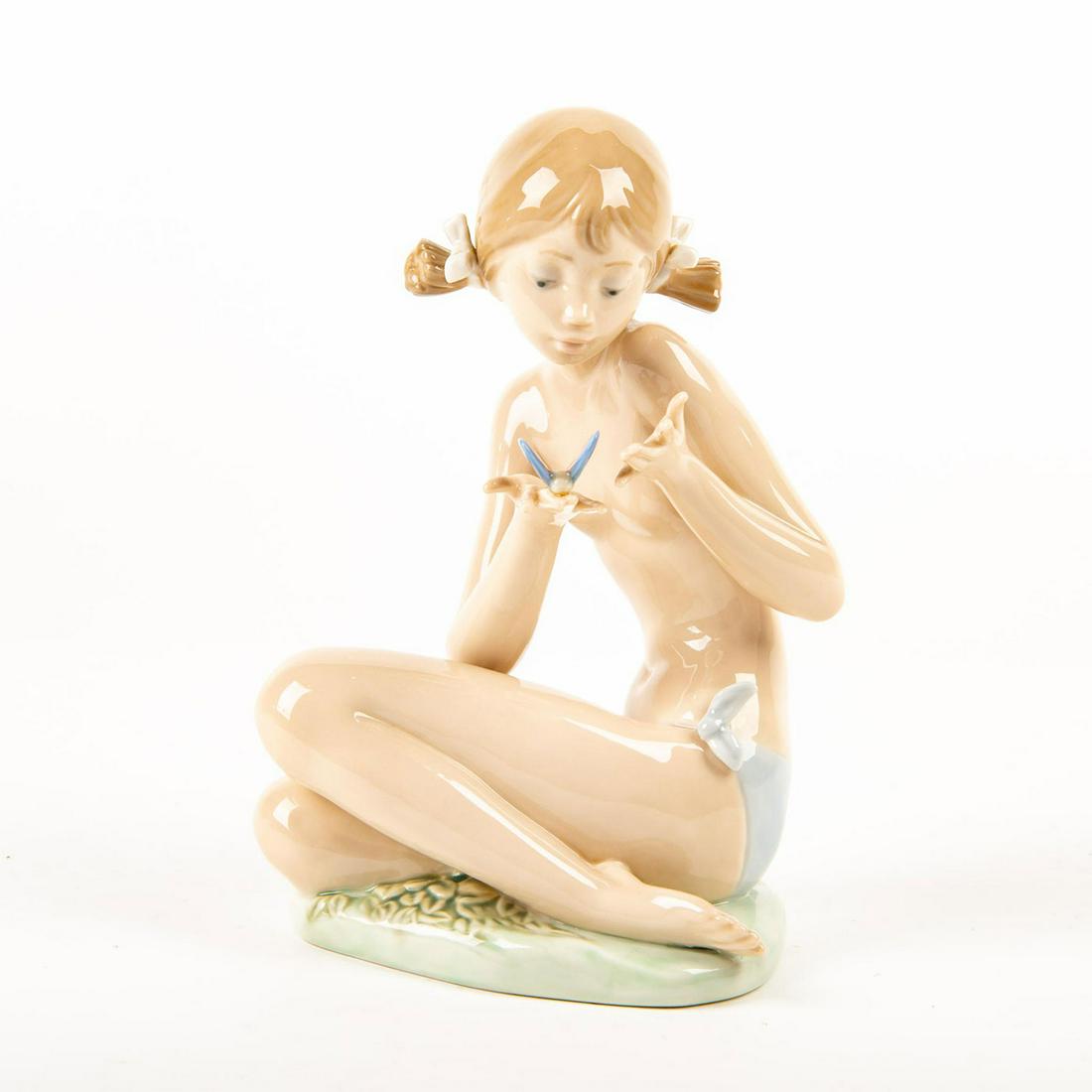 Free as a Butterfly 01001483 - Lladro Porcelain Figure: Glossy porcelain figurine modeled: girl sits on floor cradling a butterfly in hands. Lladro backstamp. Does not include original box. Artist: Salvador Debon Issued: 1985 Dimensions: 7"H Manufacturer: 