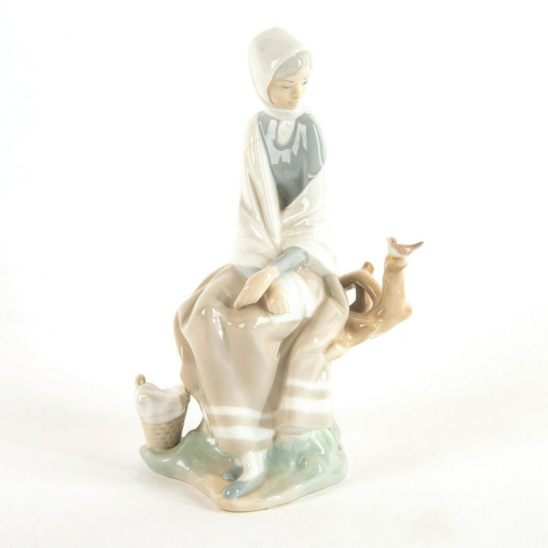 New Shepherdess 1004576 - Lladro Porcelain Figure: Glazed figure; Woman sitting on branch; dressed in white and light colors. No box, restored bird Issued: 1969/1985 Dimensions: 9.5"H Manufacturer: Lladro Country of Origin: Spain