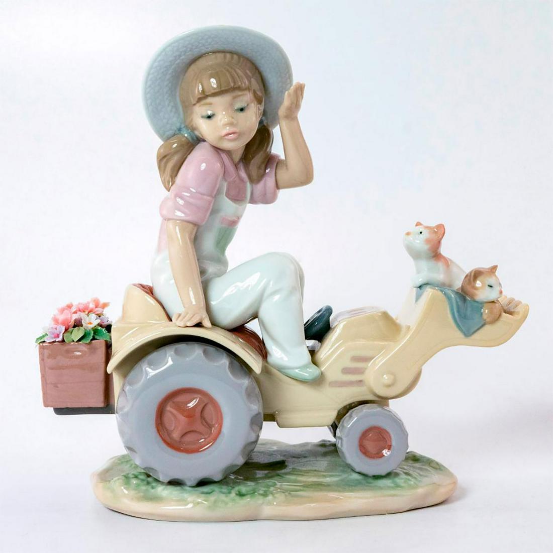 Want A Lift? 1006564 - Lladro Porcelain Figure: Girl sitting on tractor, cats inside. With original box. Lladro backstamp. Artist: Juan Ignacio Aliena Issued: 1999-2003 Dimensions: 7.75"H x 8.25"W