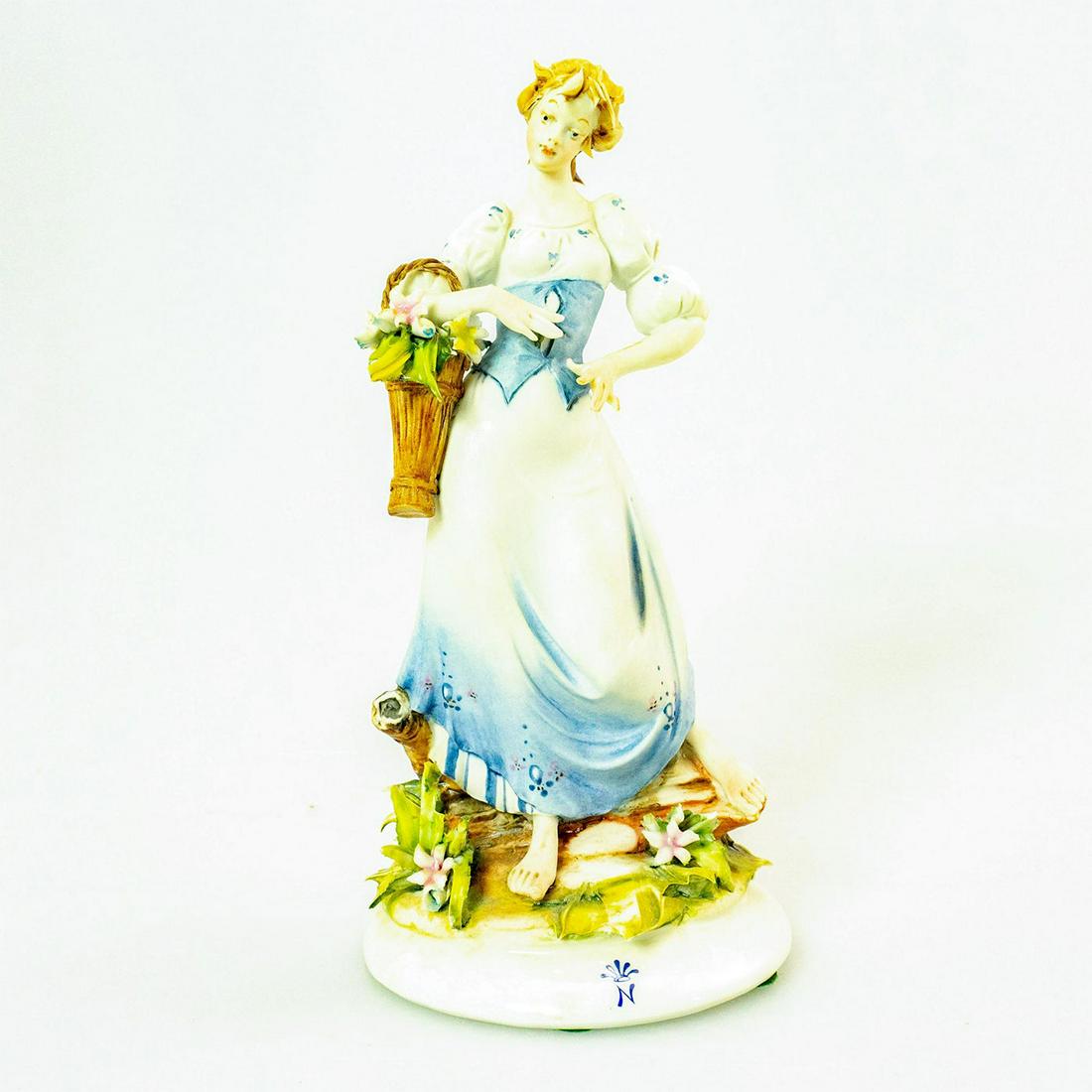 Capodimonte Quio Pezzoto Figurine, Woman With Flower: Blue, white and green coloration. Hand painted; exquisite detail; intricate floral display. Capodimonte backstamp. Marked Capodimonte by Quio Pezzoto on base. Chipped petals. Artist: Qui Pezzoto Issue