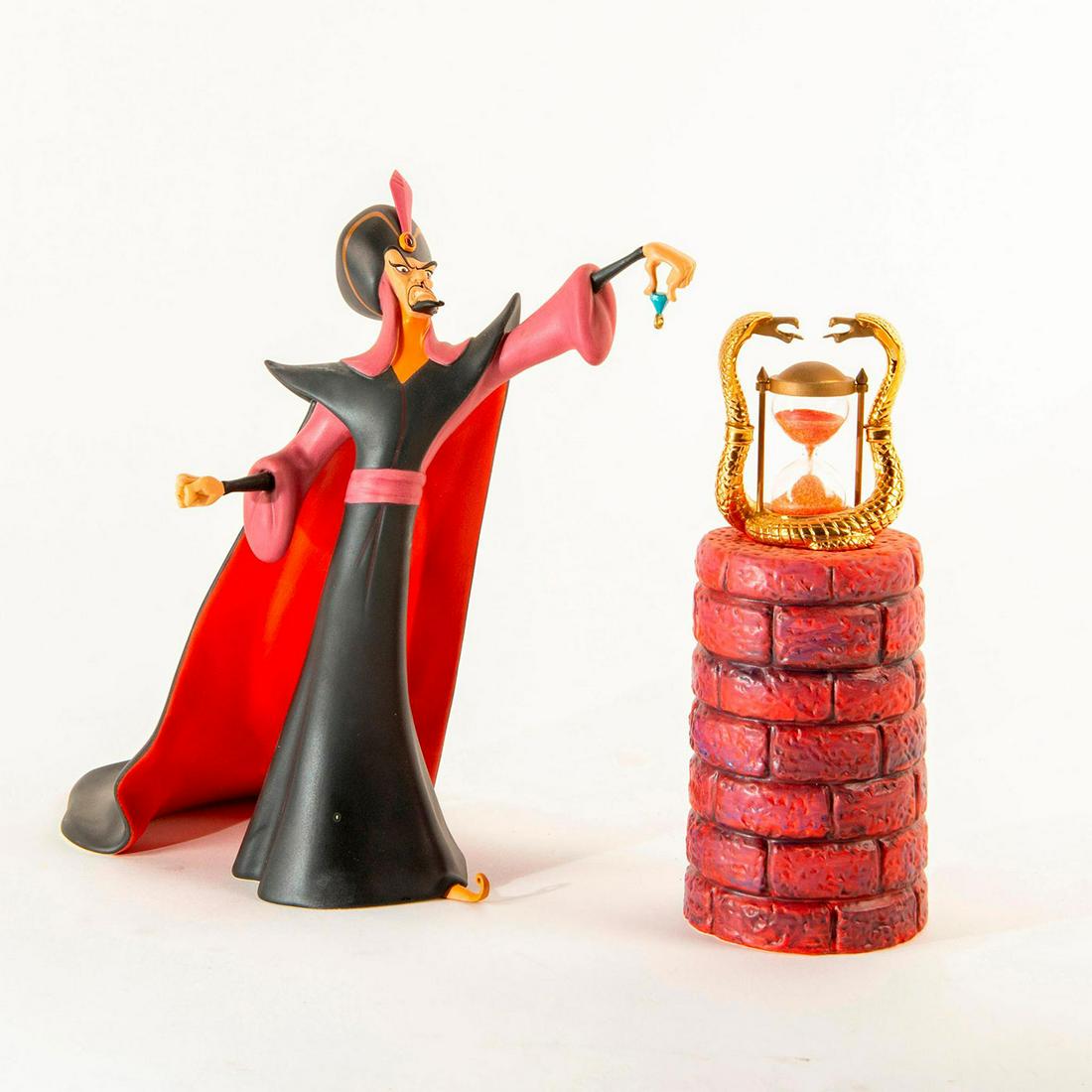 Disney Classics Figurine, Jafar, Oh Mighty Evil One: Jafar with a pedestal holding an hourglass with red sand, decorated with golden King Cobras. Includes original box. Includes certificate. Issued: 1998 Dimensions: 8.75"H Country of Origin: Thailand Ma