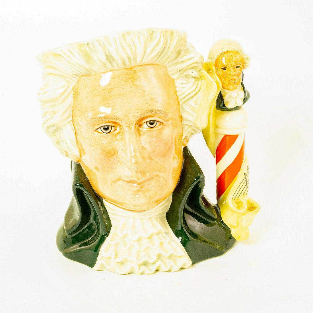 Mozart D7031 - Large - Royal Doulton Character Jug: Mozart in black white and red coloration. Series: Great Composers. Artist: Designed by Stanley J. Taylor. Issued: 1996-2001 Dimensions: 7'H Manufacturer: Royal Doulton Country of Origin: England