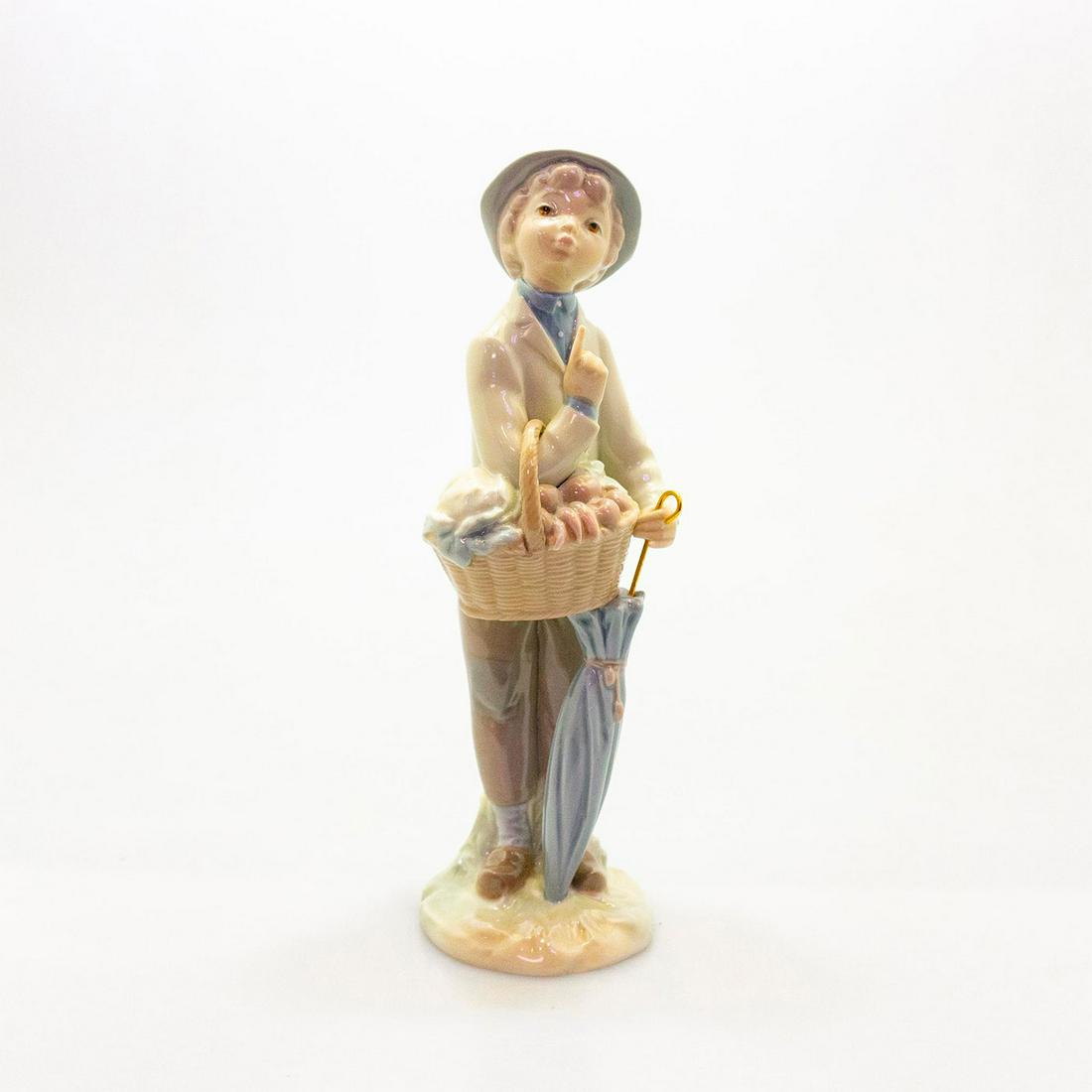Little Gardener 01004726 - Lladro Porcelain Figure: Boy with umbrella and basket. Blue and tan coloration; glossy porcelain. W. box. Lladro backstamp. Artist: Julio Fernandez Issued: 1970-1978 Dimensions: 9.75"H Manufacturer: Lladro Country of Origin: 