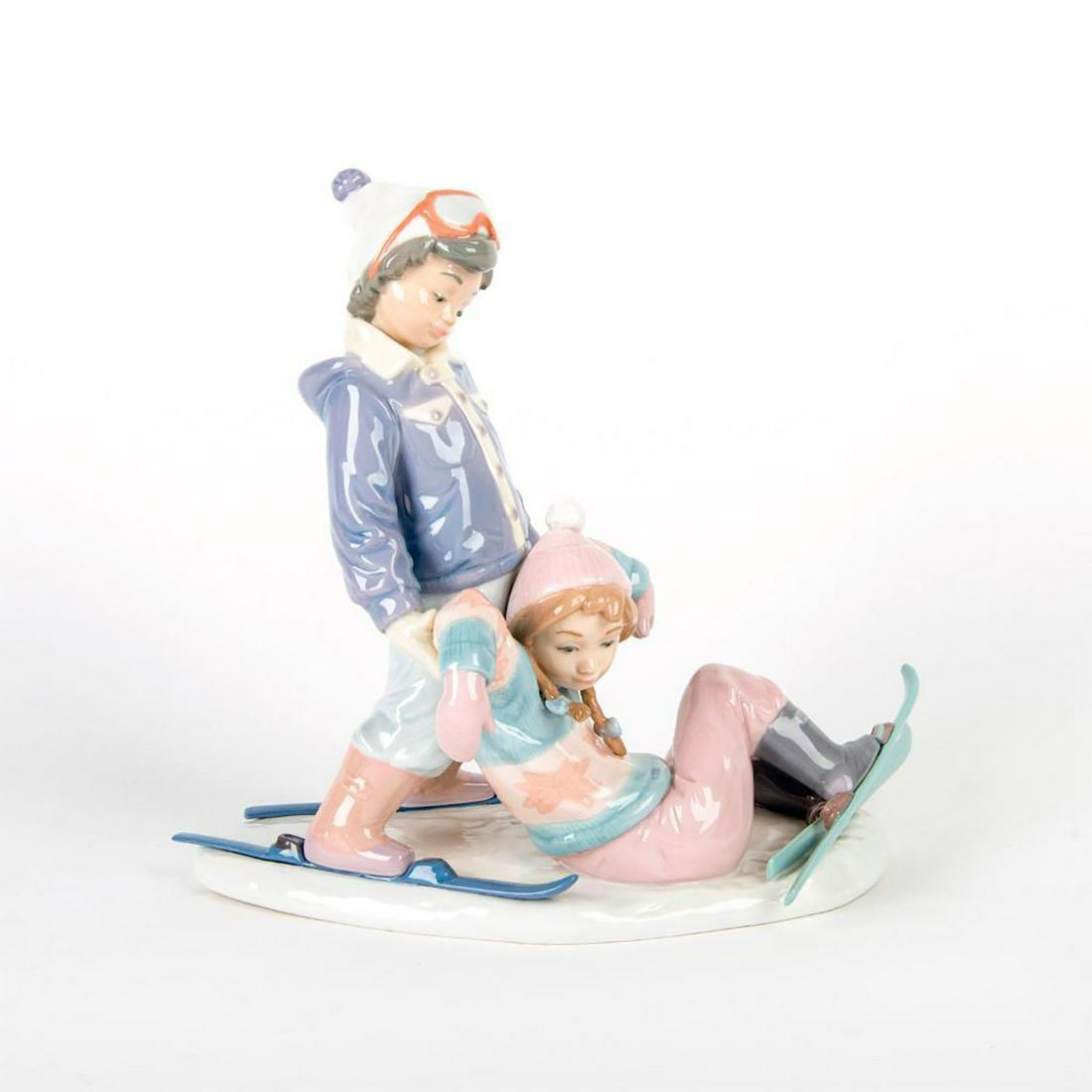 One More Try 1005997 - Lladro Porcelain Figurine: Young children learning to ski. Boy is helping girl up. With original box. Lladro backstamp. Artist: Antonio Ramos Issued: 1993-1996 Dimensions: 10"H
