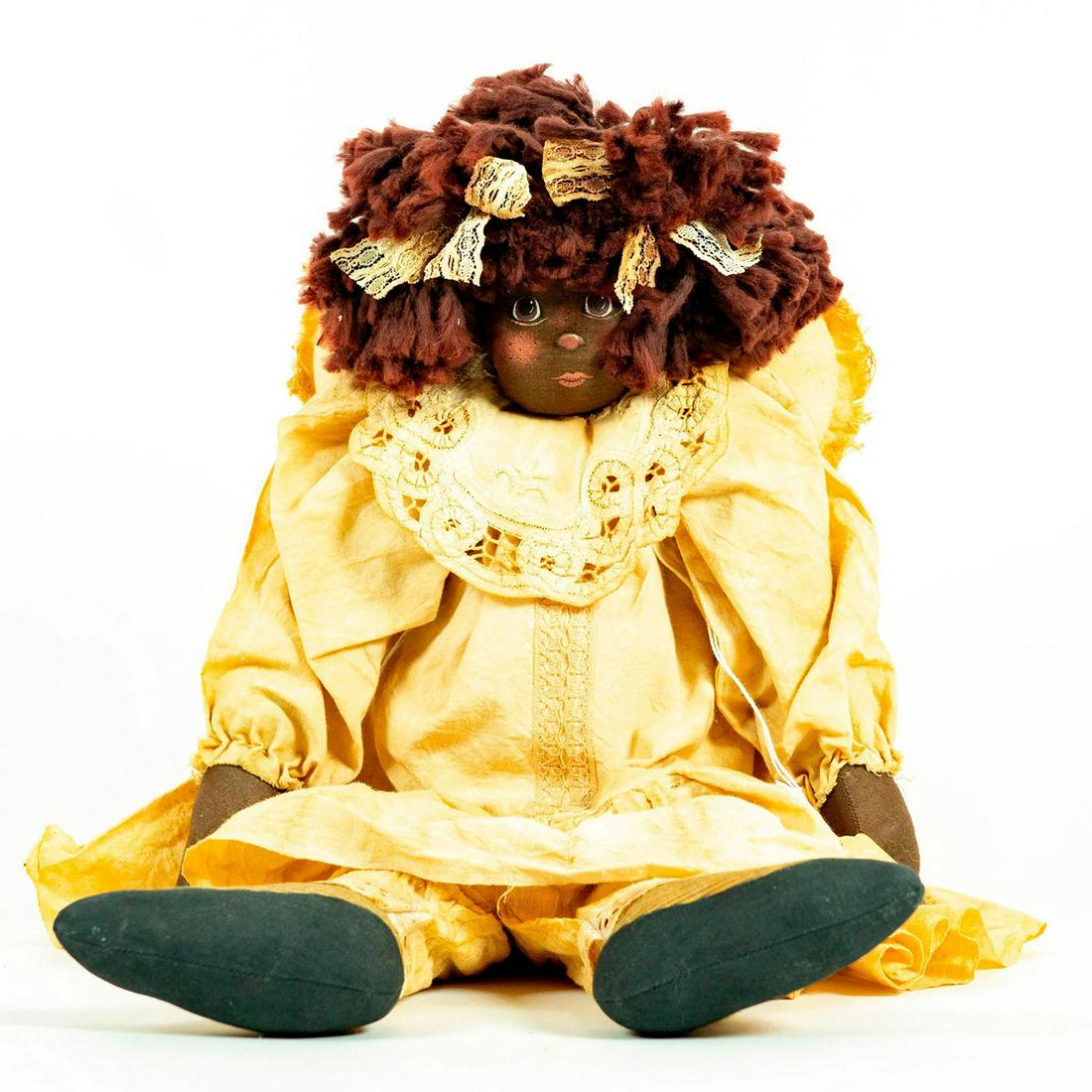 Vintage Doll: Dressed in faded white with lace bib, ribbons in the hair, and heart shaped pillow attached to back. Original tag attached under right arm. Artist signature and date on back. Artist: K Drayie Issued: