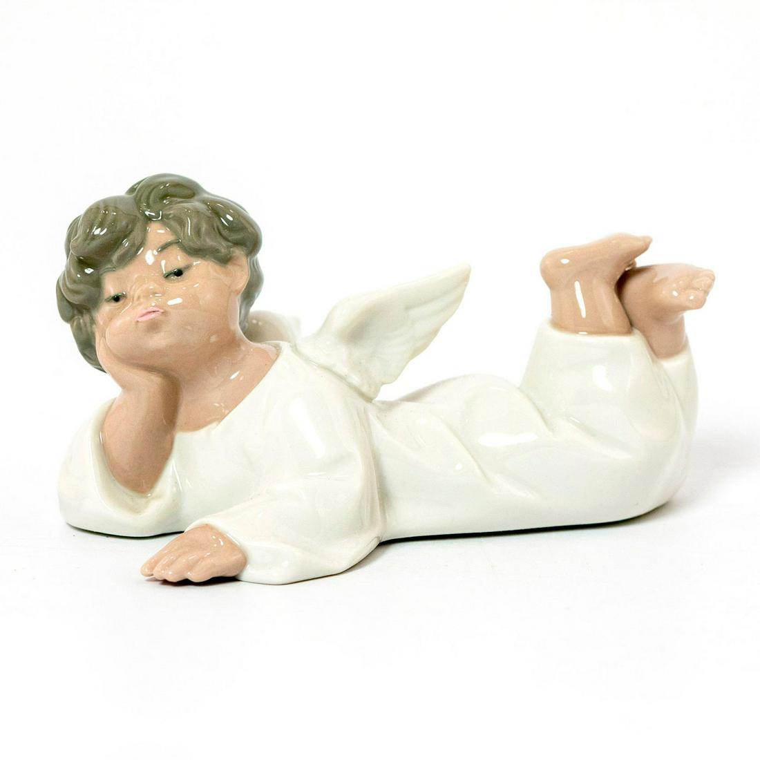 Angel, Reclining 1004541 - Lladro Porcelain Figurine: Glossy porcelain; modeled as an angel . Includes original box. Lladro backstamp. Artist: Fulgencio Garcia Issued: 1969 Dimensions: 2.25"H x 5.5"W Manufacturer: Lladro Country of Origin: Spain