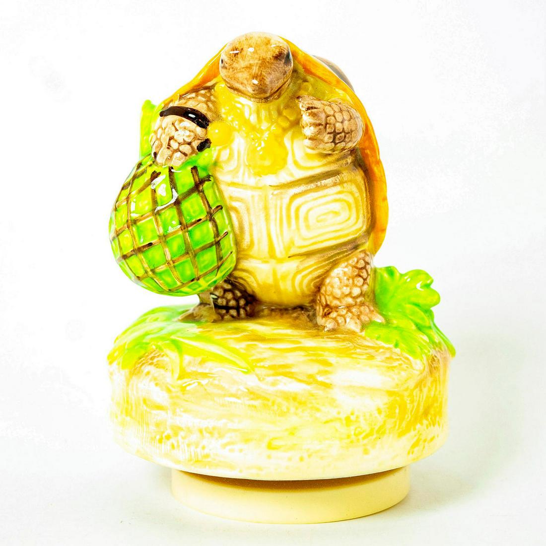 Schmid Music Box, Beatrix Potter, Mr. Alderman Ptolemy: Turtle standing atop a grassy green rotating music box. Schmid backstamp. Original manufacture's label. Inscription on side reading 'Mr. Alderman Ptolemy, Beatrix Potter, Schmid'. Issued: 1992 Dimensi