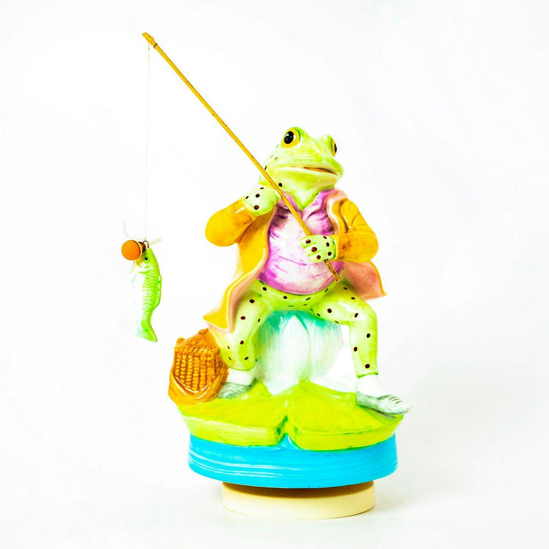 Schmid Music Box, Beatrix Potter, Mr. Jeremy Fisher: Frog fishing with fish on end pole with bait in mouth. Standing on rotating musical base. Original manufacture's label. Inscription reads 'Mr. Jeremy Fisher, Schmid, Beatrix Potter'. Issued: c.1990 Di