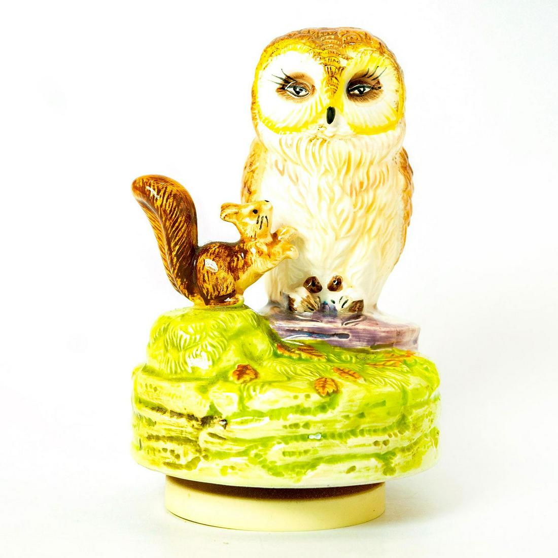 Schmid Music Box, Beatrix Potter, Squirrel Nutkin: Owl and Squirrel on grassy green rotating musical base. Schmid backstamp. Original manufacture's label. Inscription on back reading 'Squirrel Nutkin, Beatrix Potter'. Issued: 1978 Dimensions: 7"H Manu