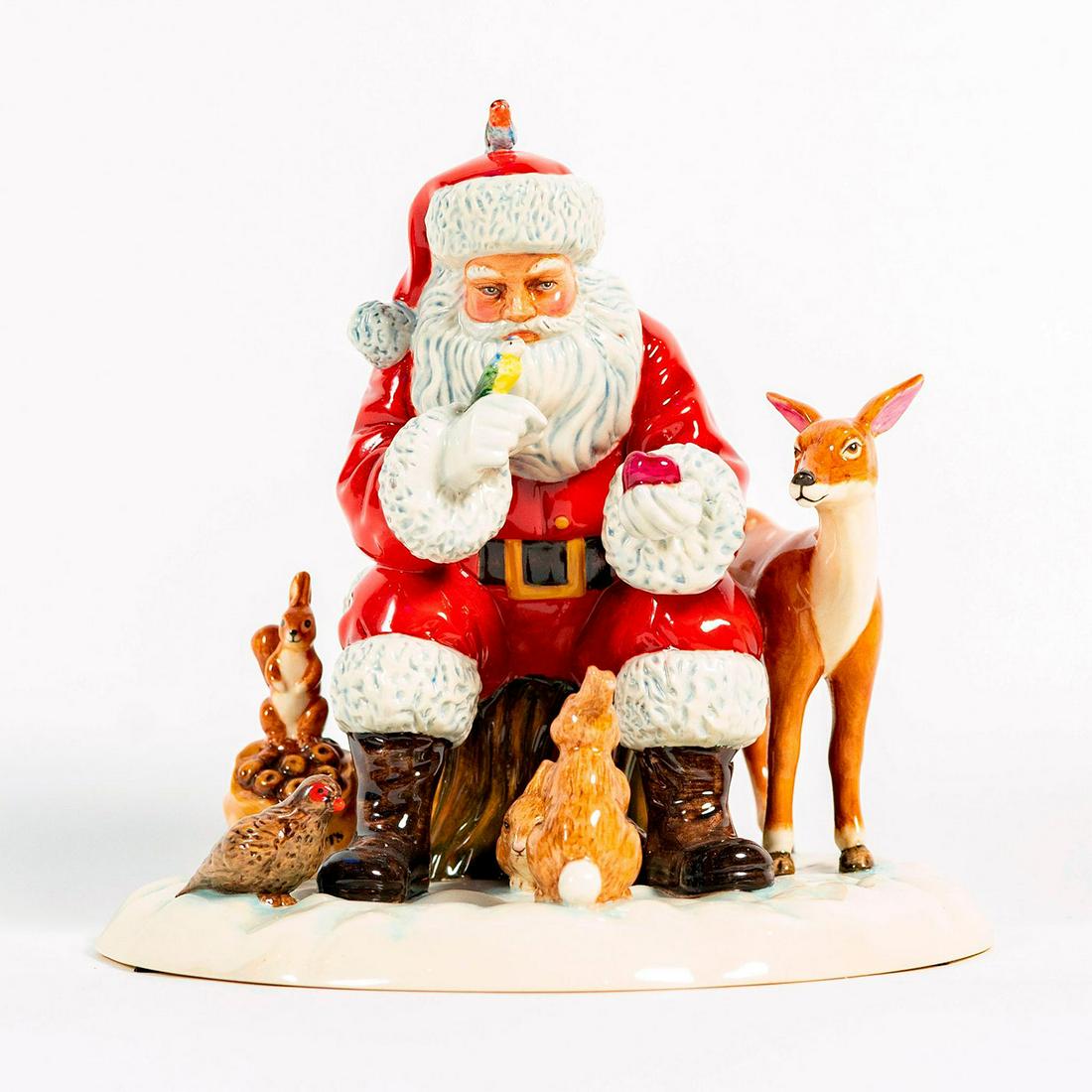 A Woodland Christmas HN5855 - Royal Doulton Figurine: A Woodland Christmas depicts Santa seated on a log amidst the snow and surrounded by forest animals including birds, rabbits and deer, as he offers them a little festive cheer. Royal Doulton backstamp