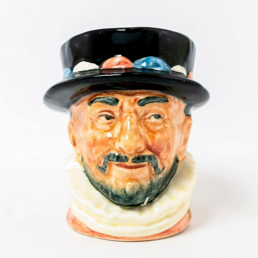 Beefeater Gilded D6233 - Small - Royal Doulton: Pink tunic, GR cypher; hand painted gold gilt highlights to cypher, collar and handle. Royal Doulton backstamp. Artist: Henry Fenton Issued: 1947 Dimensions: 3.25"H Manufacturer: Royal Doulton Country
