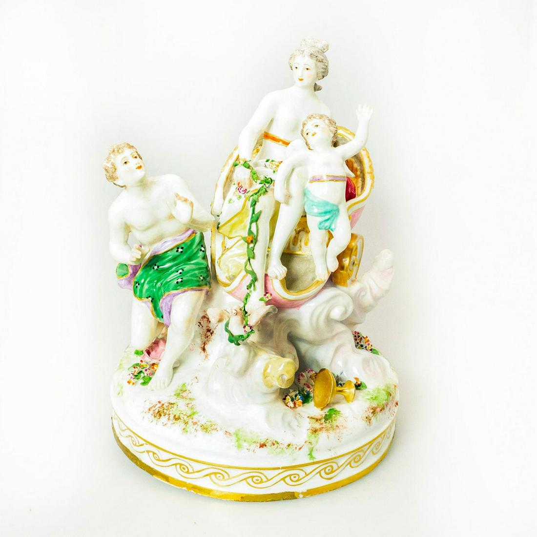 German Porcelain Figurine Grouping Venus and Cupid: Glossy porcelain figurine; Venus rides in a dove drawn chariot with cupid. Gold gilt accents. On circular base. Issued: 20th c. Dimensions: 11"H Manufacturer: Meissen Country of Origin: Germany