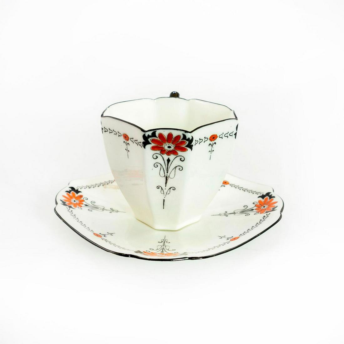 Shelley China Queen Anne Red Daisy Tea Cup and Saucer: Art Deco porcelain tea cup, and saucer. Black trim with orange highlighting the flower petals. Shelley backstamp. Issued: 20th c. Dimensions: 3"H Manufacturer: Shelley Country of Origin: England