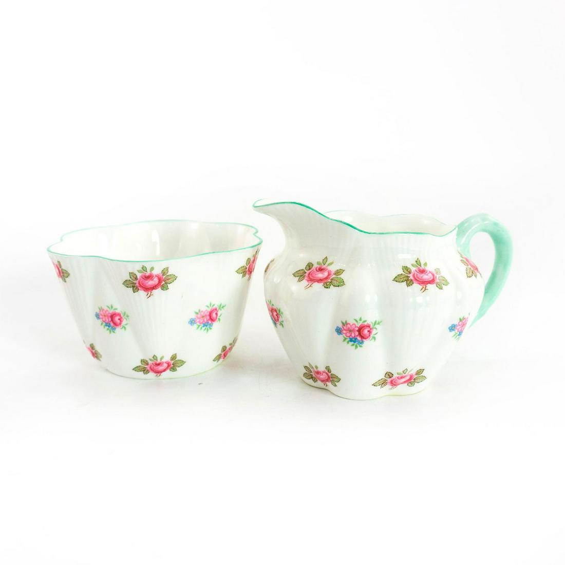 Shelley Fine Bone China Sugar Bowl And Creamer, Rosebud: Rosebud pattern. Glazed bone china with pink and blue flora; green trim. Shelley backstamp. Issued: 20th c. Dimensions: 2.75"H Manufacturer: Shelley China Country of Origin: England