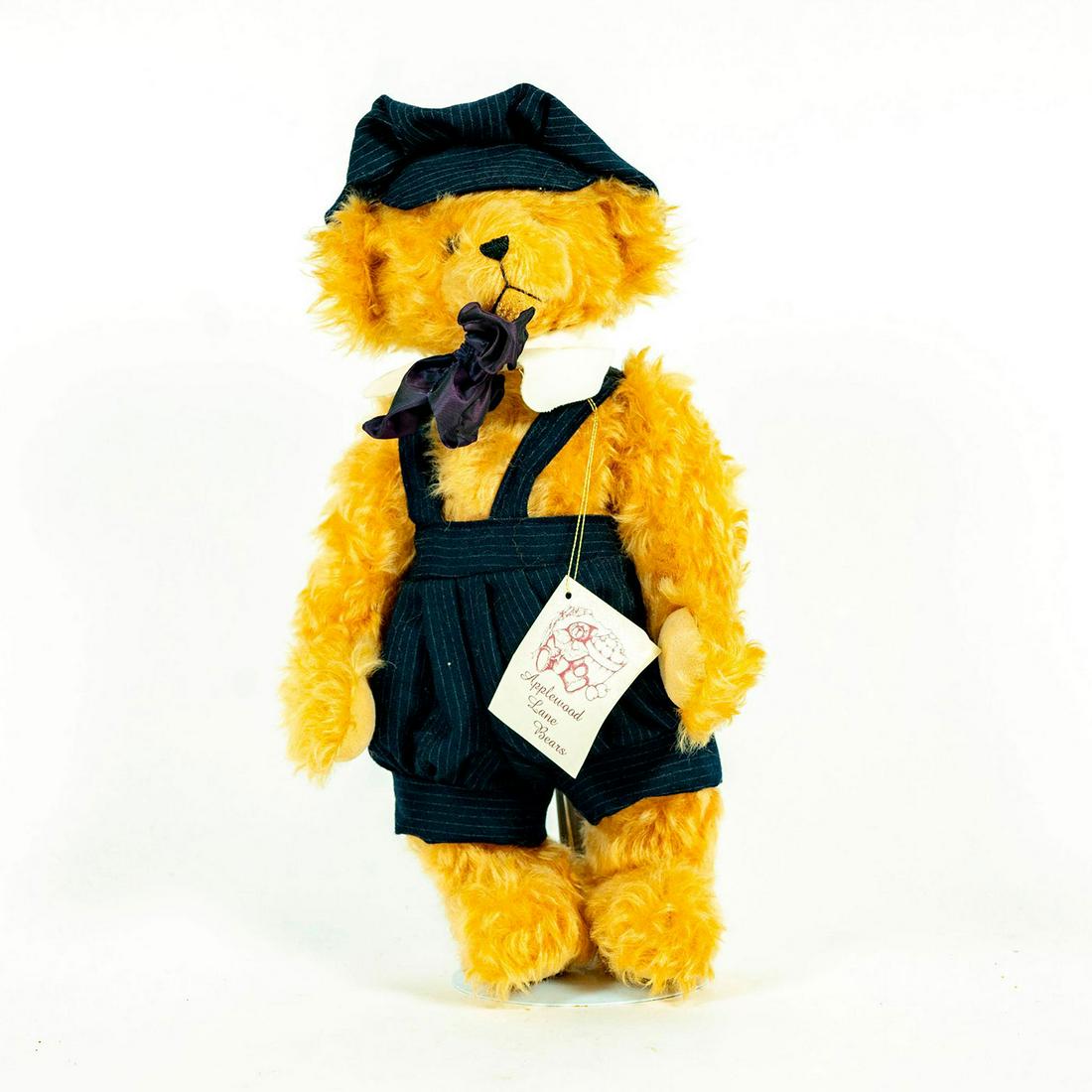 Applewood Lane Bears, Mikey: Light brown bear; Navy blue striped outfit and hat. Purple bowtie. With stand. Artist: Joan Davis Issued: 20th c. Dimensions: 15"H Manufacturer: Applewood Lane Bears Country of Origin: USA