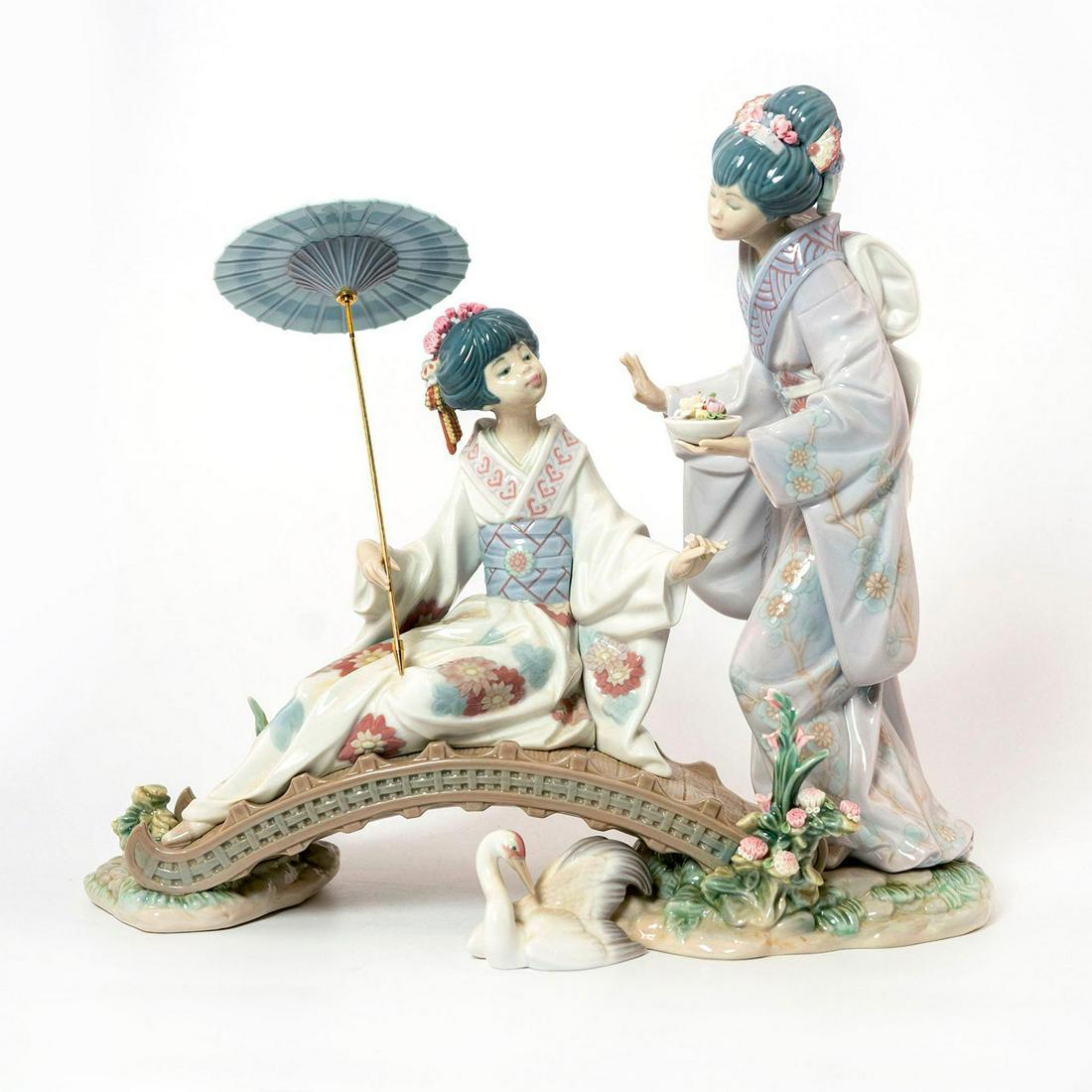 Springtime in Japan 1001445 - Lladro Porcelain Figurine: Glossy large porcelain; modeled as Geisha's on a bridge. No original box. Lladro backstamp. Umbrella is detached from figure, possibly not the correct pole. Missing flowers to headdress. Artist: Salva