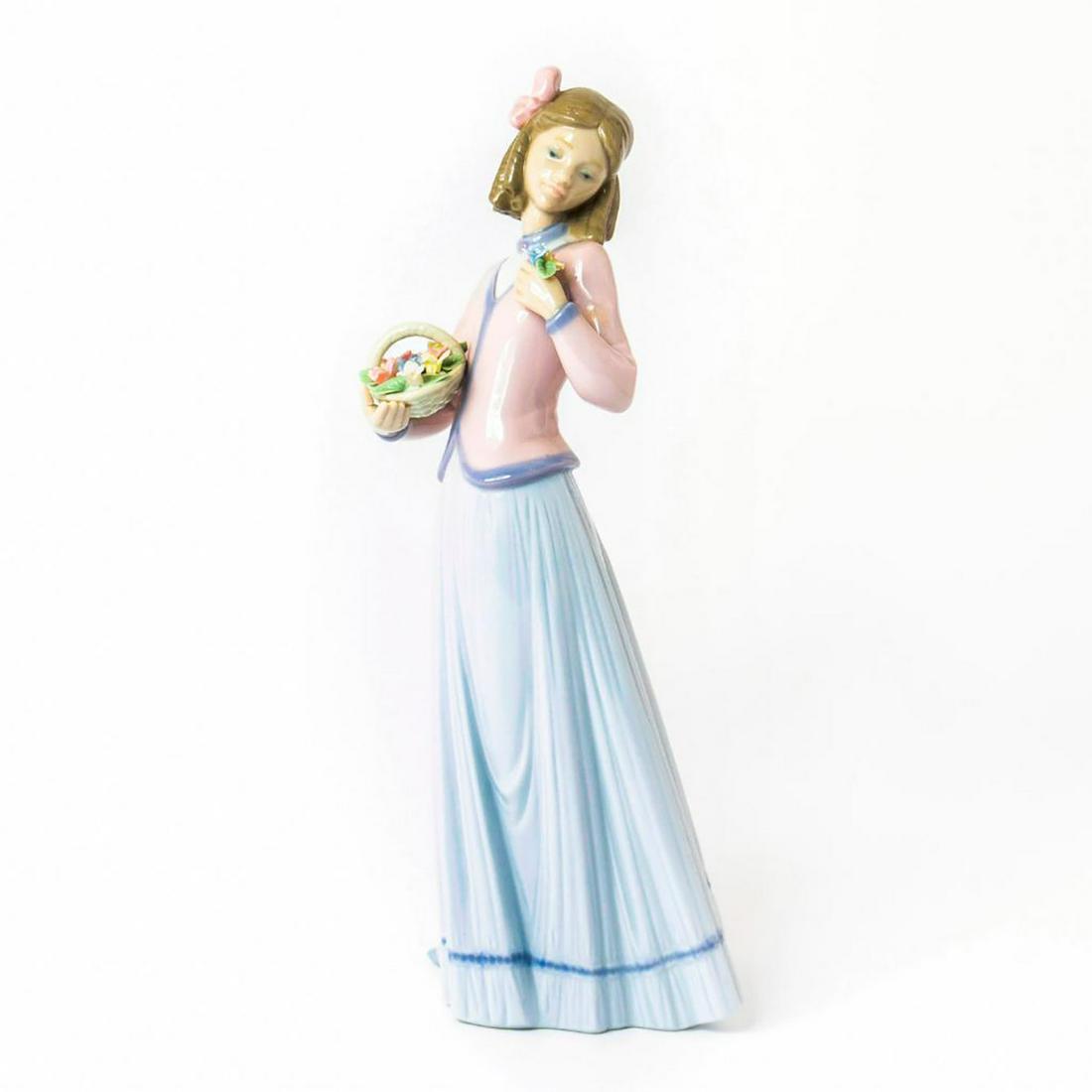 Innocence in Bloom 1007644 - Lladro Porcelain Figurine: Glossy porcelain; modeled as a girl with a basket of beautiful flowers. 1996 Collector's Society figure. Lladro and Collector's Society backstamp. Repaired thumb. Artist: Jose Puche Issued: 1996 Dimen