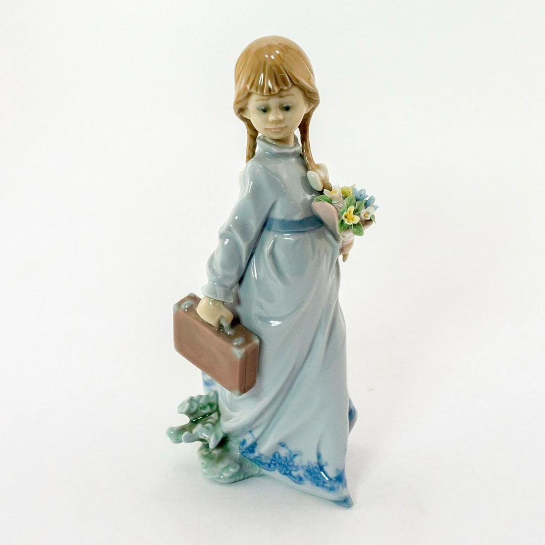 School Days 1007604 - Lladro Porcelain Figurine: Glazed; Young girl in blue dress, holding suitcase and flowers. Missing leaf and petal in bouquet. No box. Lladro backstamp. Artist: Antonio Ramos Issued: 1988 Dimensions: 8.25"H