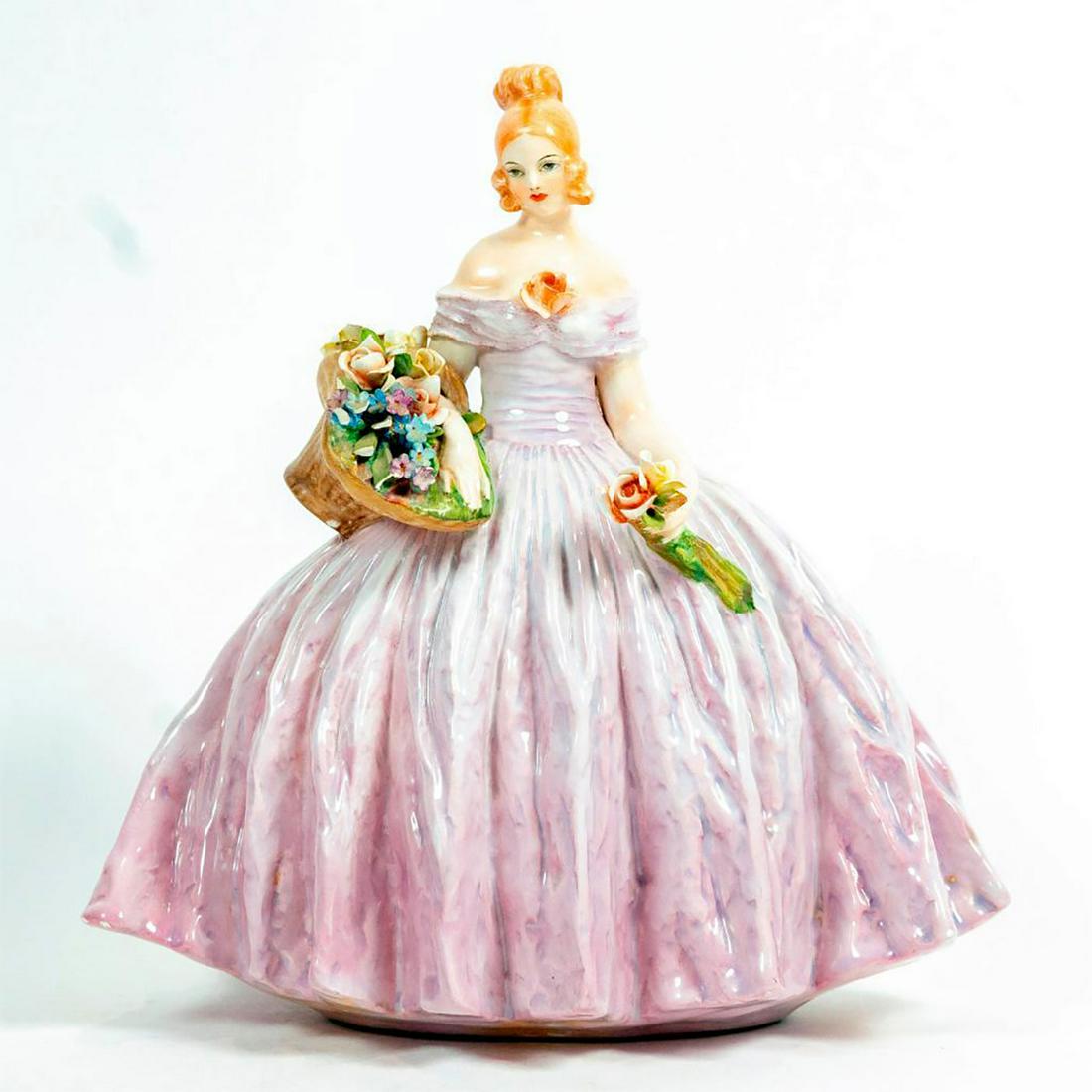 Guido Cacciapuoti Figurine, Lady Holding Flowers: Glazed; Beautiful woman in large, pink dress. Chips to multiple flowers and leaves in basket. Signed by the artist. Guido Cacciapuoti backstamp. Issued: 1930's Dimensions: 10.5"H Manufacturer: Guido C
