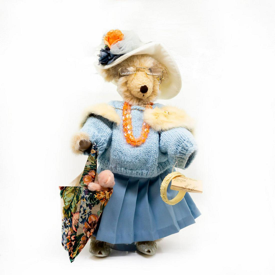 Barbara's Originals Honey Cups Teddy Bear, Auntie Ethel: Fully jointed, mohair, glass eyes, sewn nose, shaved snout, poly filled. Wearing a beautiful blue knitted sweater and an elegant skirt to match. She has a big hat on her head with floral accents. She 