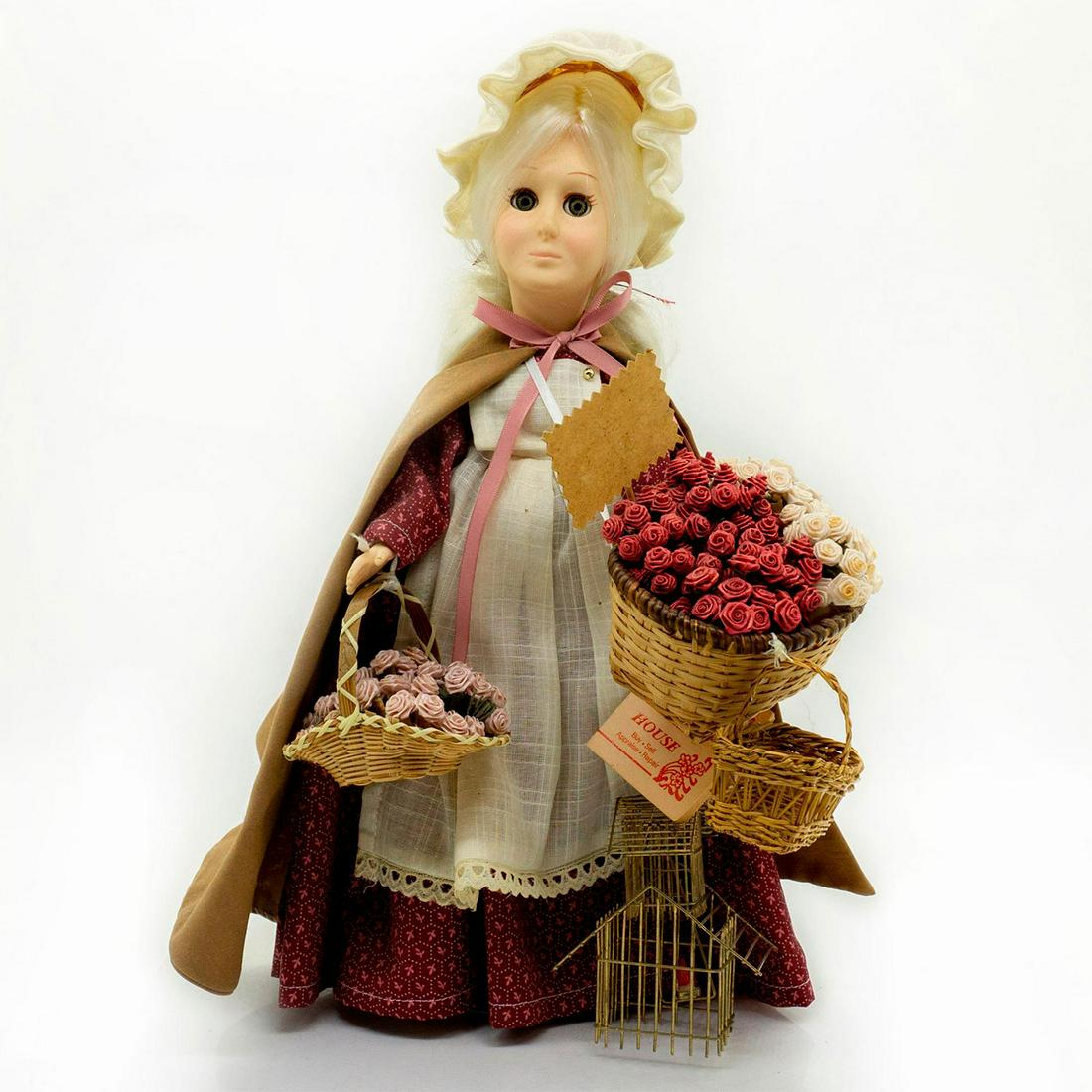 Doll Clearing House Doll, The Rose Peddler: Doll with long white hair. Burgundy dress with off white apron. Large flower basket with lots of flowers. With stand. Manufacture tag. Artist: Linda Sue Issued: 20th c. Dimensions: 14"H Manufacturer: 