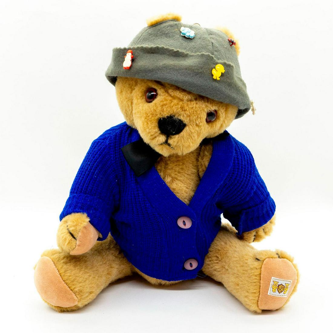 Nisbet Bears, Grinnee Bearit 85-5210 Teddy Bear: Worldwide Limited Edition 310 of 5,000. This bear is fifth Nisbet Celebrity Bear to be produced under the Dakin Nisbet flag. Wearing blue knit sweater, black satin ribbon and grey hat with various pin