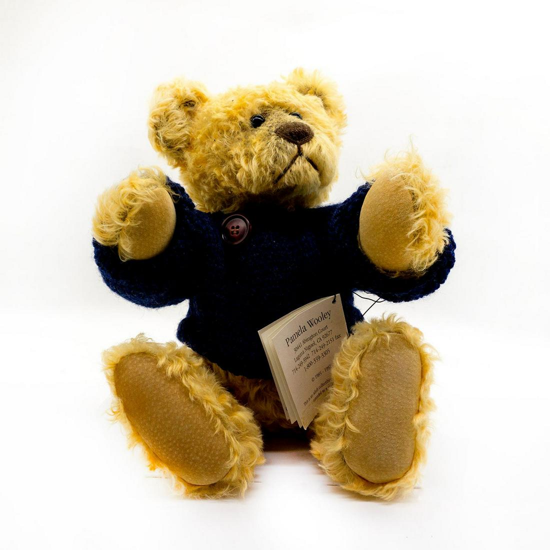 Pamela Wooley Teddy Bear, Daleney: Fully jointed, mohair, glass eyes, shaved snout. Wearing a stylish blue sweater with a red button on the chest. Original tags included. Artist: Pamela Wooley Issued: 1998 Dimensions: 13"H Country of O