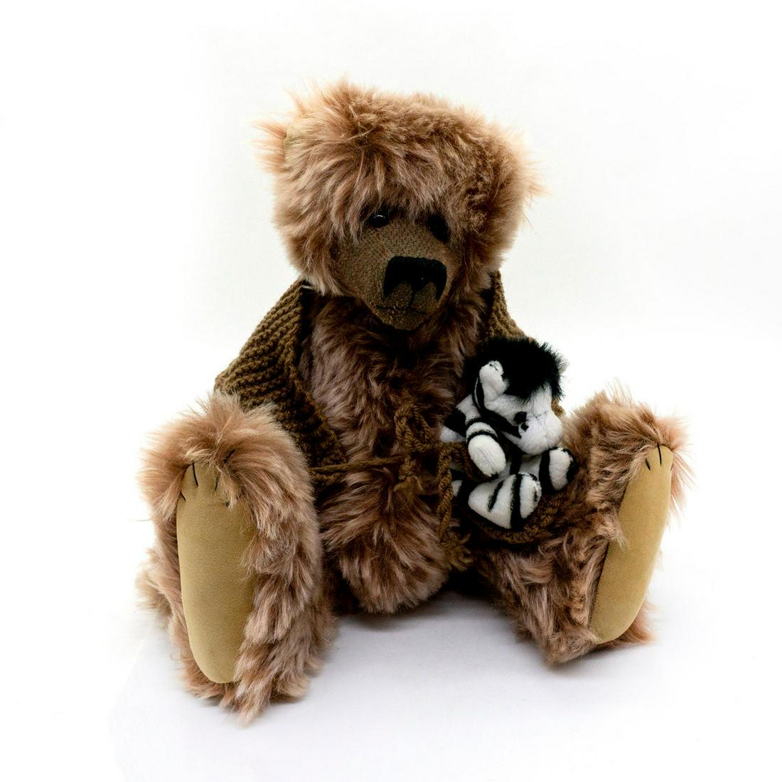 Strawbeary Teddy Bear, Granville: Fully jointed, mohair, glass eyes, shaved snout. Wearing a stylish brown knitted coat and holding a small plush zebra. Original tags attached. Artist: Jackie Eeles Issued: 1999 Dimensions: 12.5"H Coun