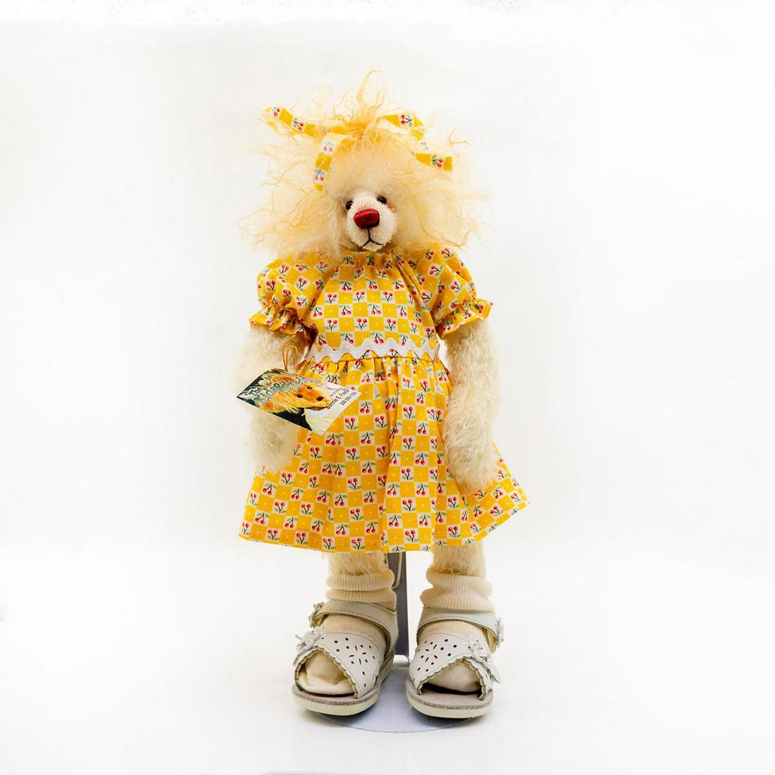 The Kids and Teddy Too Teddy Bear, Alma: Fully jointed, mohair, German glass eyes, shaved snout. Wearing a stylish yellow dress with cherries on it and a hair tie to match. Also wearing some white sandals with white socks. Original tag attac